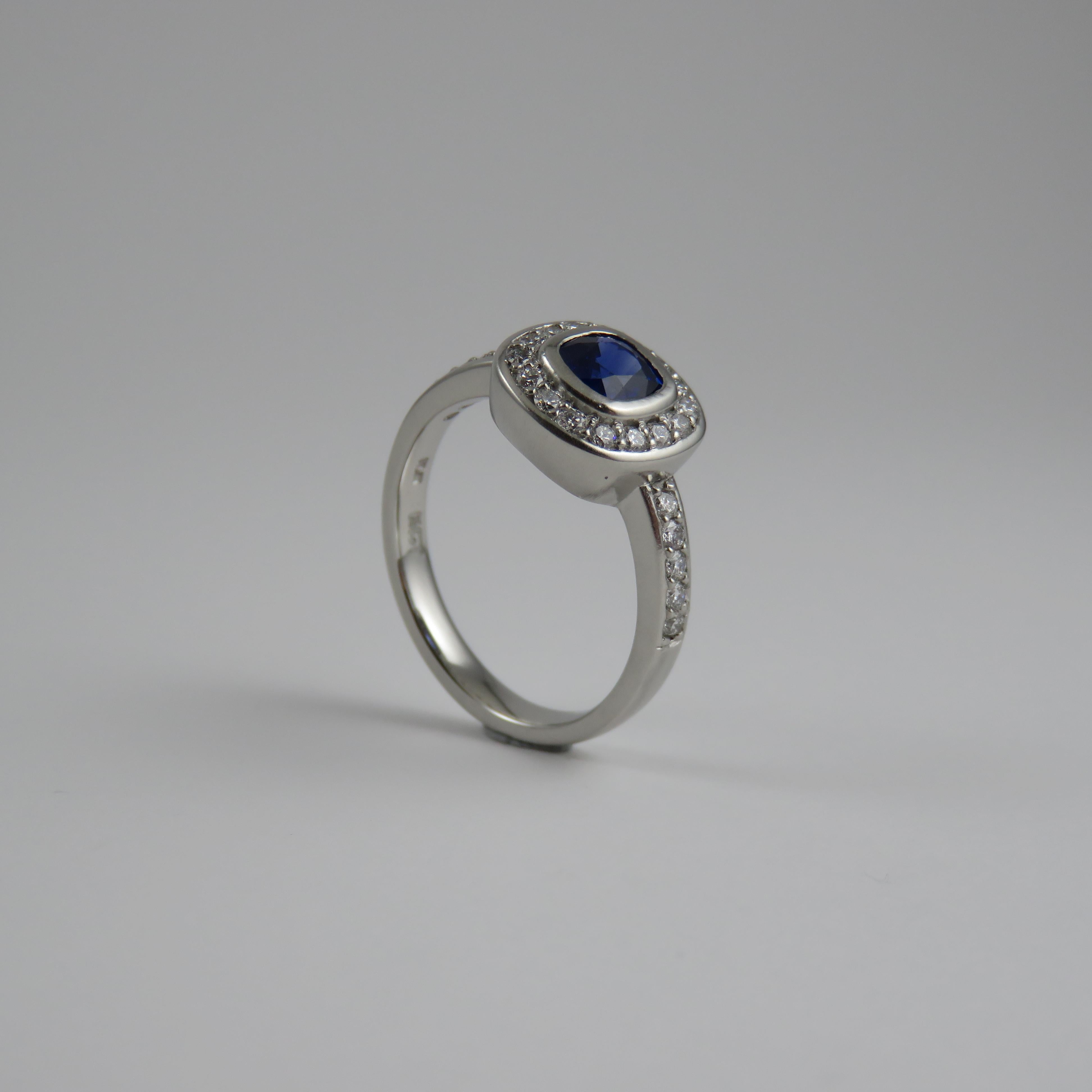 The visual elegance of sapphire with it's slightly dark violet blue color is second to none in this masterpiece design cluster style engagement ring in Platinum, with the beautiful blue sapphire with center proud rub over bezel setting totaling 0.86