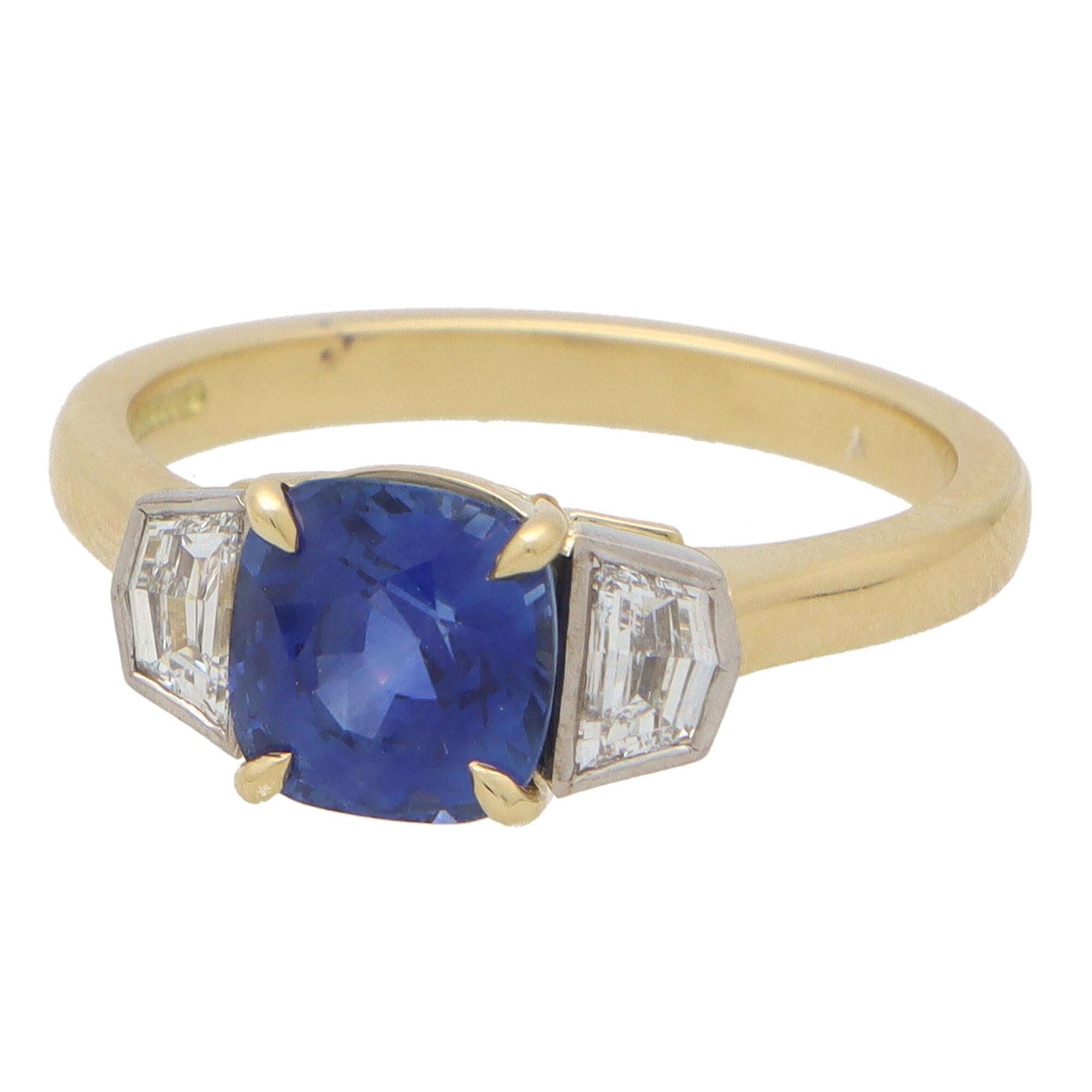 Magnifique bague de fiançailles à trois pierres en saphir bleu et diamant, sertie d'or jaune 18k et de platine.

La pièce est principalement sertie d'un saphir bleu naturel taillé en coussin, solidement fixé au centre par quatre griffes. De part et