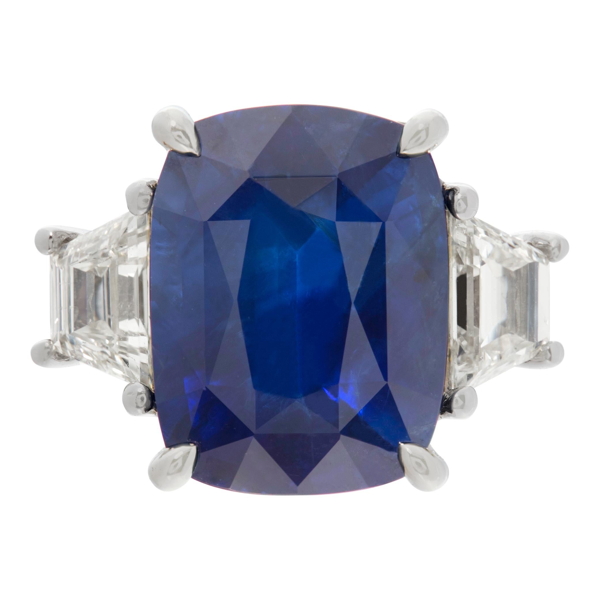 Cushion cut blue Sapphire & diamonds ring set in 18K white gold. Brilliant cushion cut sapphire: 5.47 carats, with 2 trapezoid cut diamonds, total approx. weight: 0.63 carat, estimate: G-H Color, VS Clarity. Size 6.75.This Diamond/Sapphires ring is
