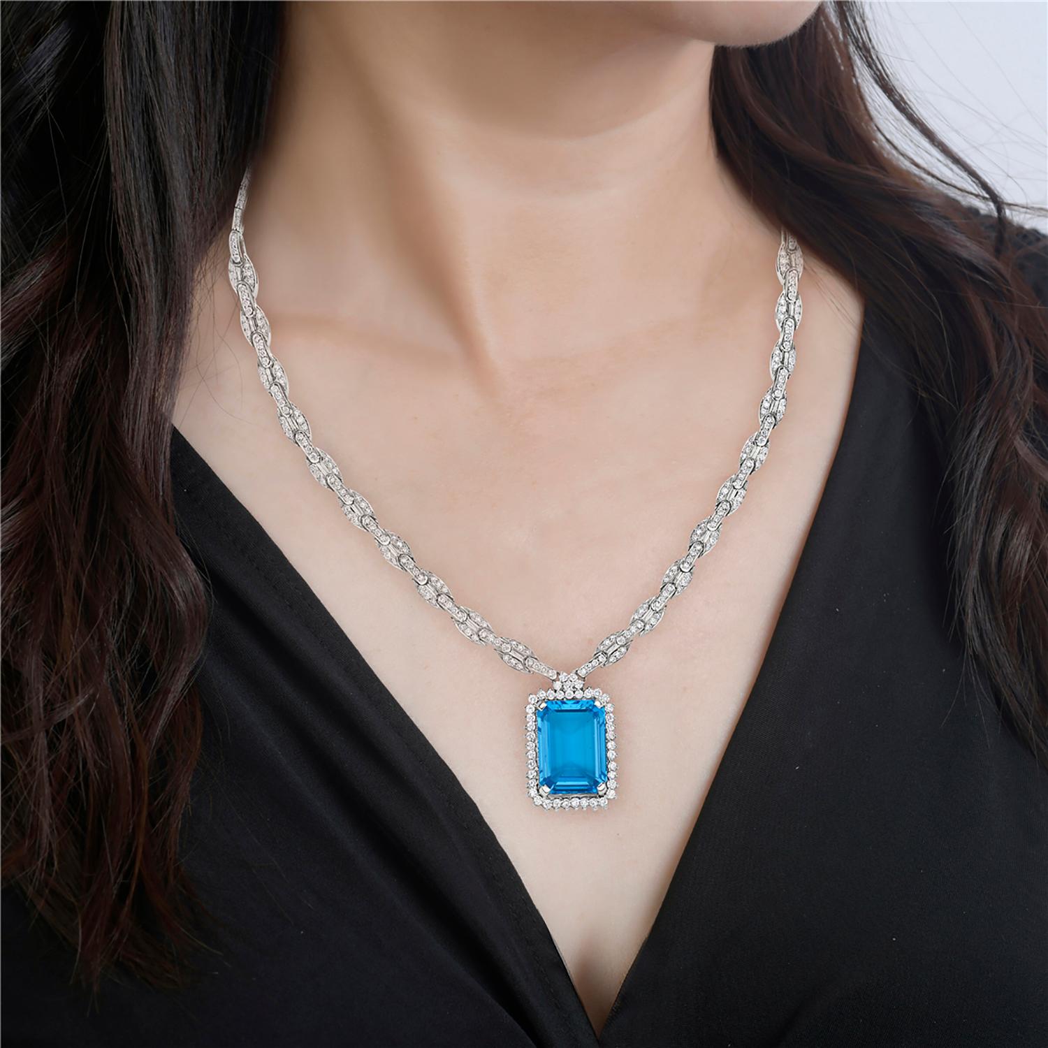 Diese exquisite Halskette mit einem fesselnden blauen Topas im Kissenschliff, der mit einer Reihe von diamantbesetzten Verbindungsstücken verbunden ist, ist in luxuriösem 18-karätigem Weißgold gefasst. Der leuchtende und kräftige Blautopas wird