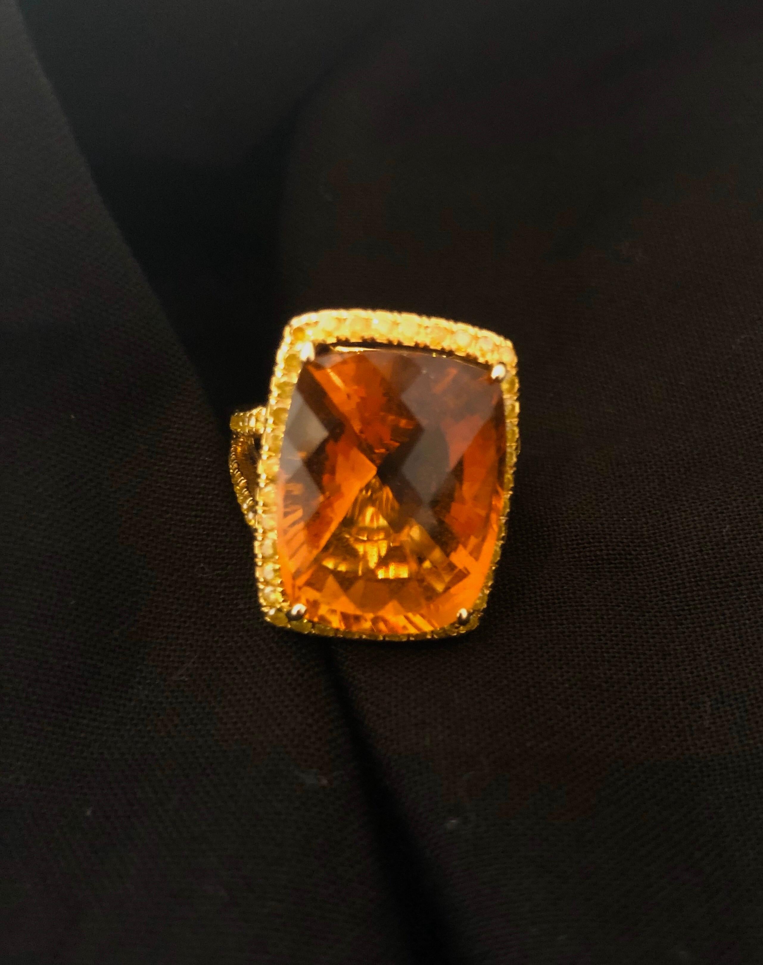 A beautiful ring, centered around a checkerboard, cushion cut, citrine weighing approximately 12ct. Crafted in 18K yellow gold, in a 