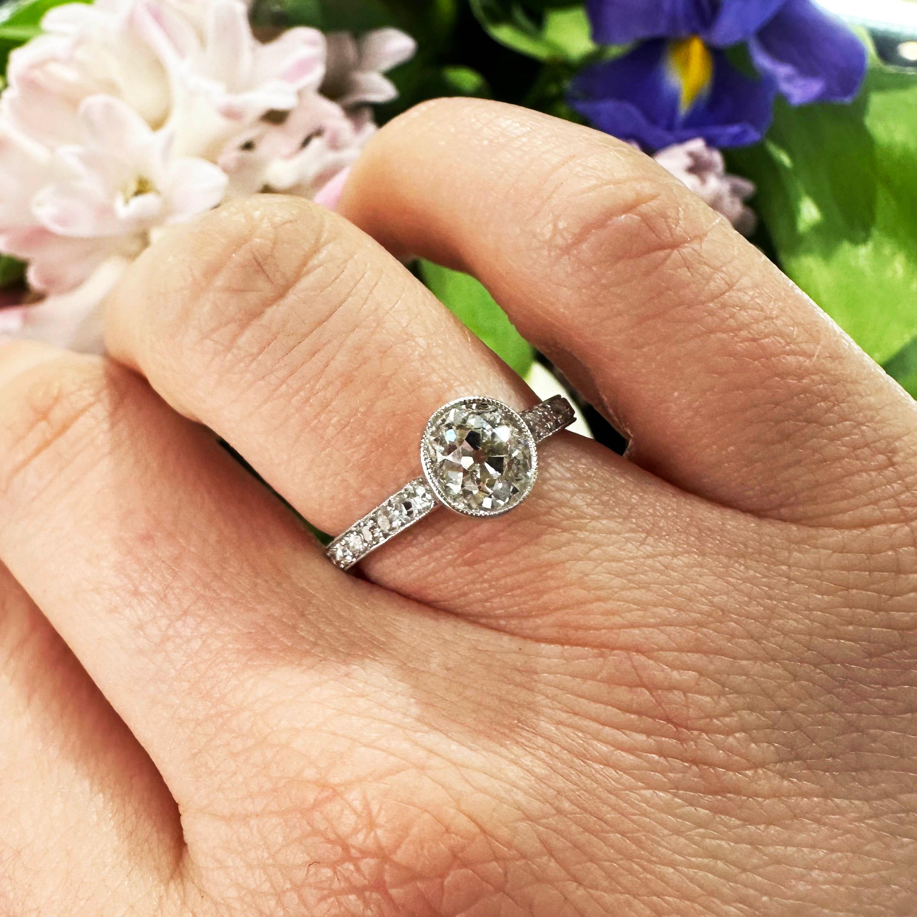 An Edwardian style solitaire diamond ring, set with an estimated 1.20ct old cushion-cut diamond, in our opinion the colour is H and our opinion of the clarity is SI2, in a millegrain edged rub over setting, with round brilliant-cut diamonds in the