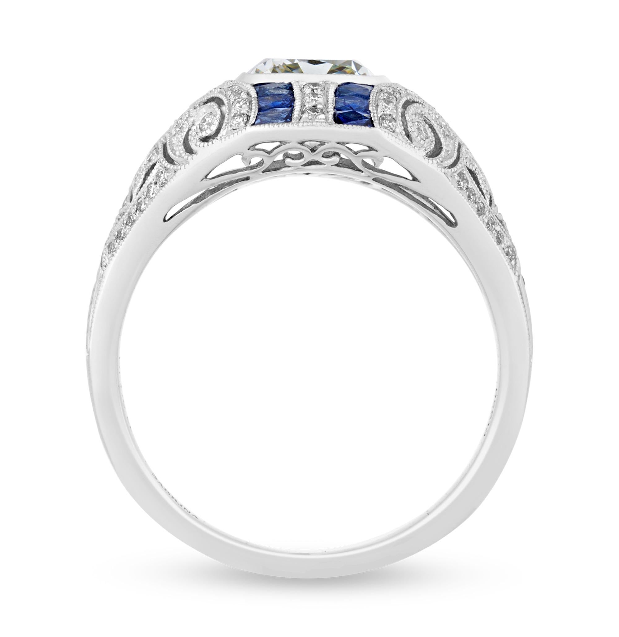 This captivating cushion-cut diamond ring, featuring a 1.60-carat center stone, perfectly embodies elegance and sophistication. Framed by sapphires in a bold north-south design, this piece is further enhanced by intricate filigree work along its