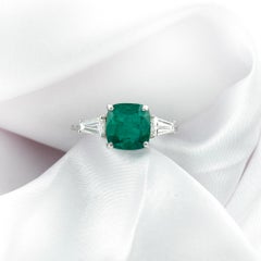 Bague en or blanc 18 carats sertie d'une émeraude taille « coussin » rehaussée de diamants