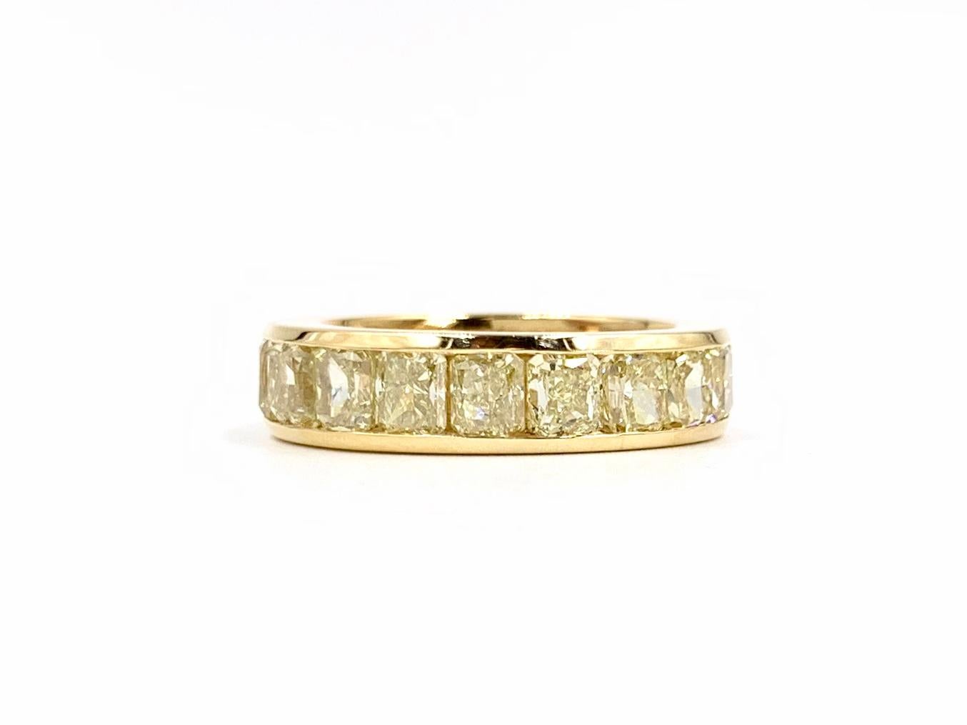 A beautiful and sleek 18 karat yellow gold cushion cut fancy yellow diamond eternity band featuring 19 diamonds at 5.98 carats total weight. Diamonds have an excellent, vibrant saturation and are very well matched. Clarity grading is approximately