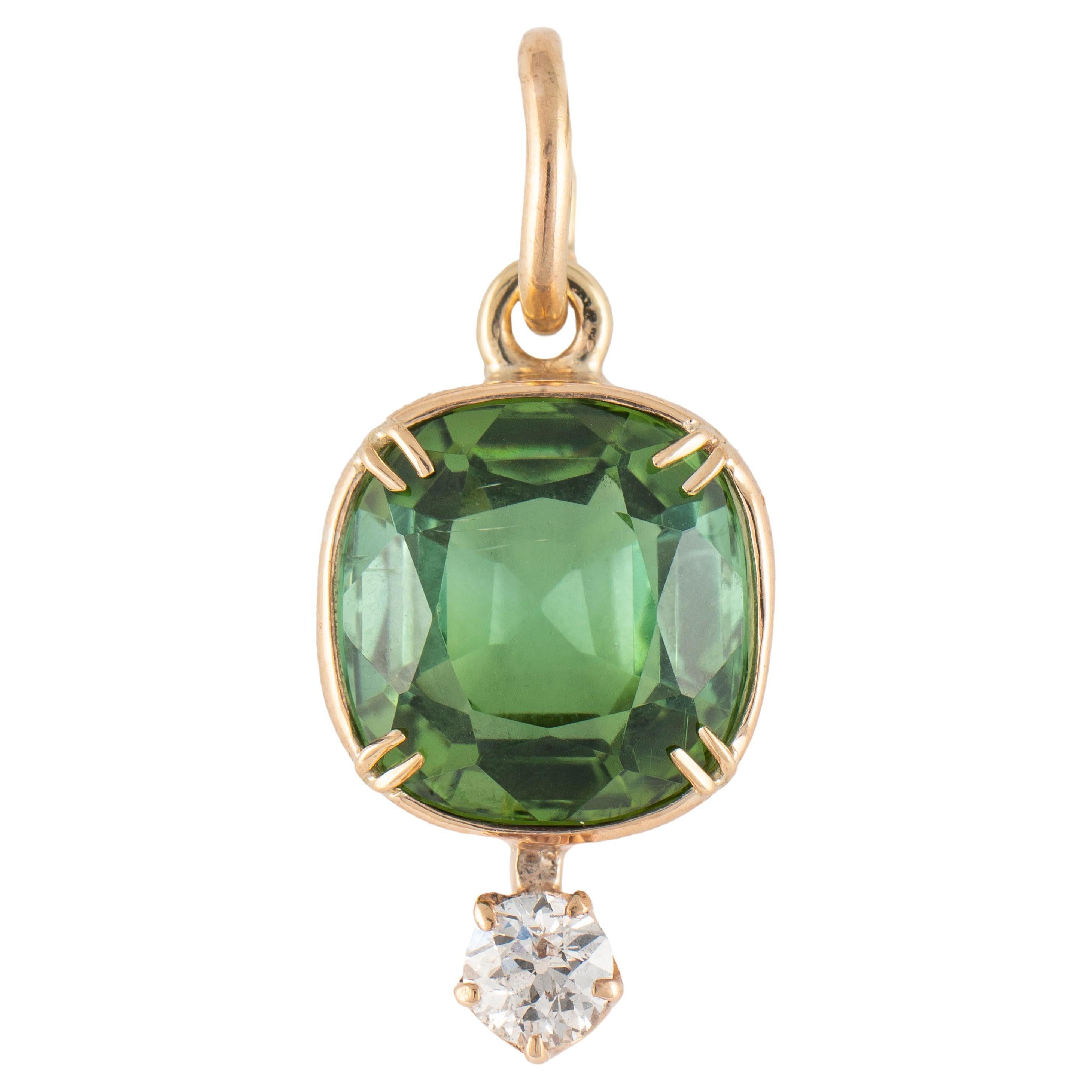 This beautiful and timeless 14k yellow gold pendant from the 1930s is bezel set with a luscious cushion-shaped green tourmaline above a prong set bright old-European-cut diamond, fitted with an oval gold suspension ring.  

Tourmaline measures 8.7 x