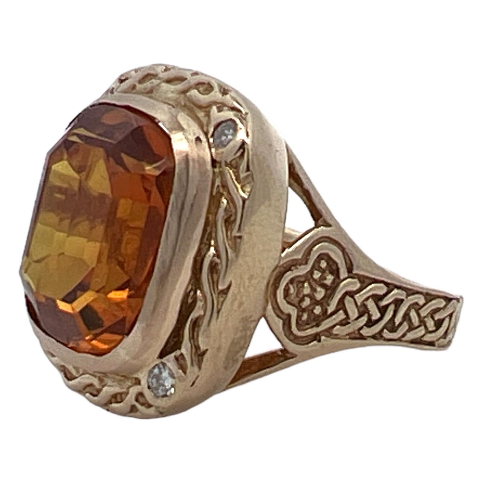 Cushion cut honey citrine diamond ring crafted in 14 karat yellow gold. The citrine measures approximately 20 x 22mm and is bezel set in a hand carved gold and diamond mounting. The 4 round briliant cut diamonds weigh approximately .12 CTW. The ring