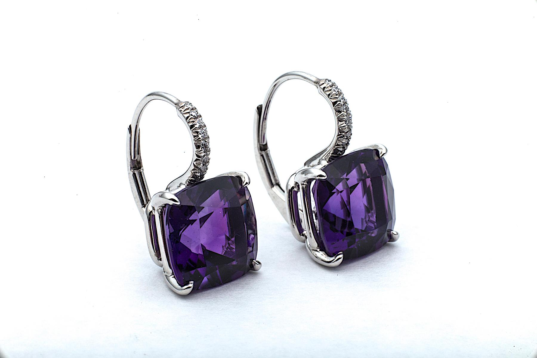 The color purple is associated with royalty, nobility, luxury, and power and these amethyst drop earrings exude those inner strengths.  Mounted in platinum, these cushion cut medium size amethyst gems, weighing a total of 6.84 carats, hang