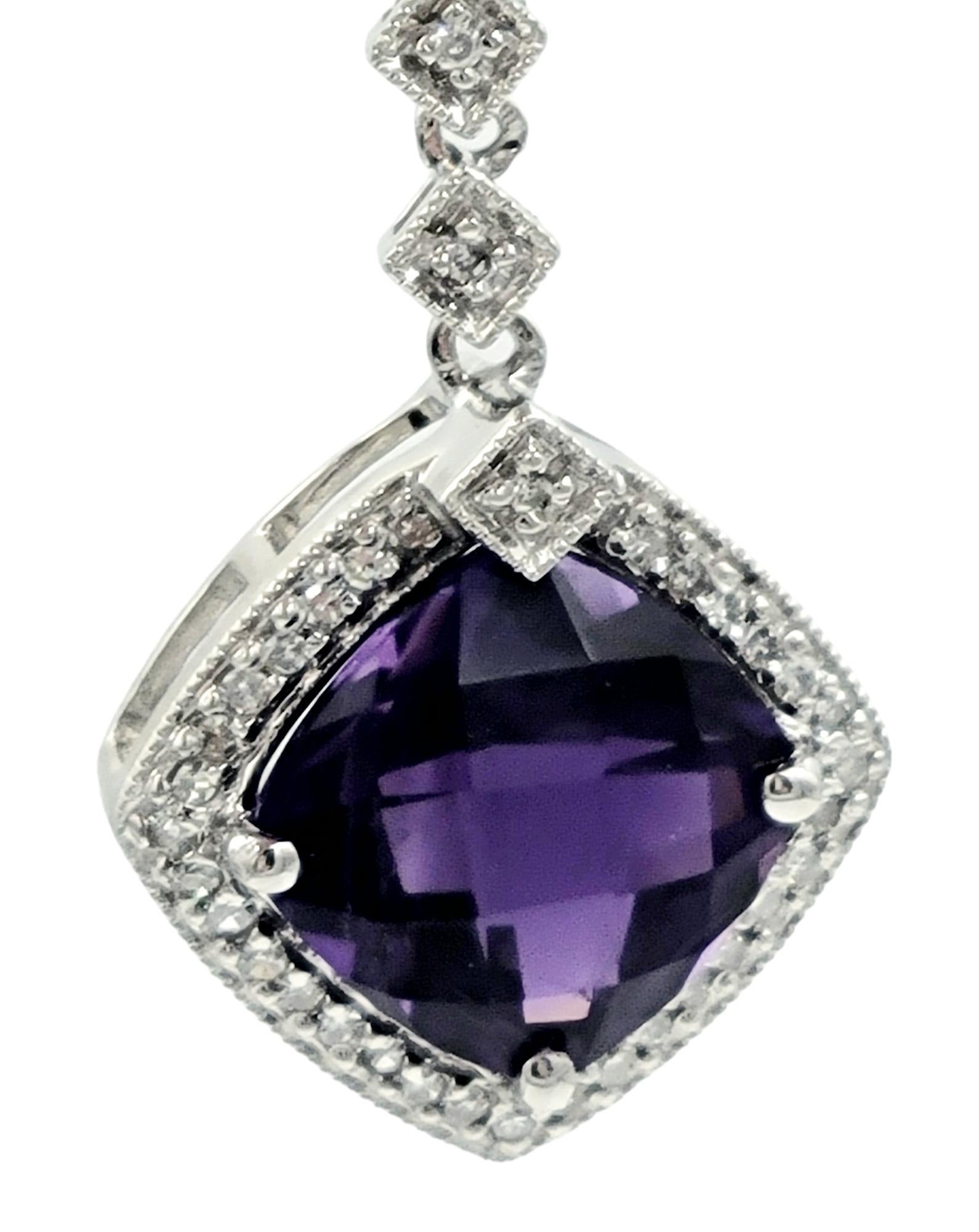 This pendant necklace, set in elegant 14 karat white gold, showcases a sophisticated and harmonious design. The central feature is a cushion-cut amethyst, exuding a rich purple hue. Surrounding the amethyst is a sparkling halo of diamonds, adding