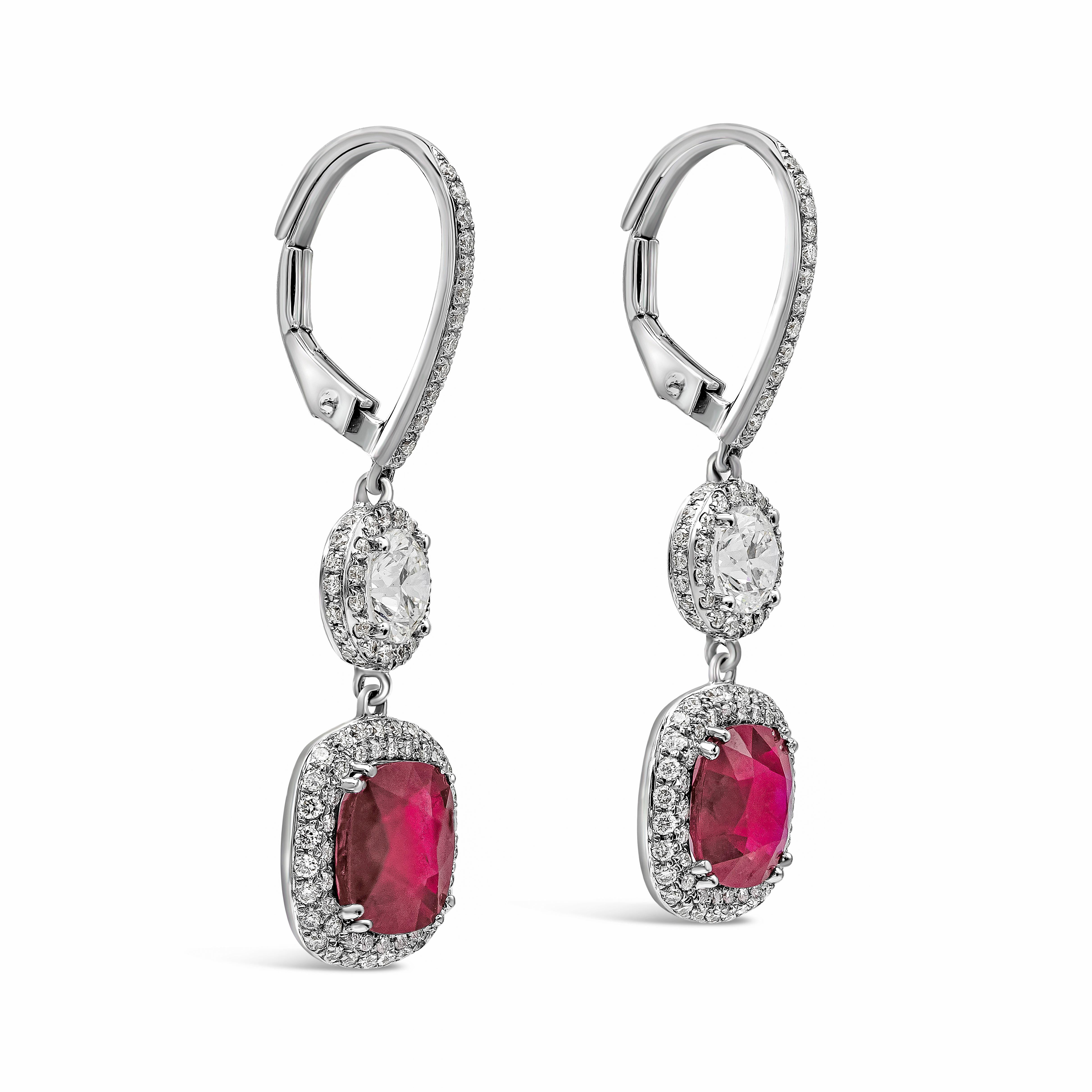 These gorgeous earrings feature 2 cushion cut rubies weighing 4.15 carats total and accented with brilliant round diamonds in a micro-pave setting. Suspended on a round brilliant diamond weighing 0.89 carats with a single row of round melee diamonds