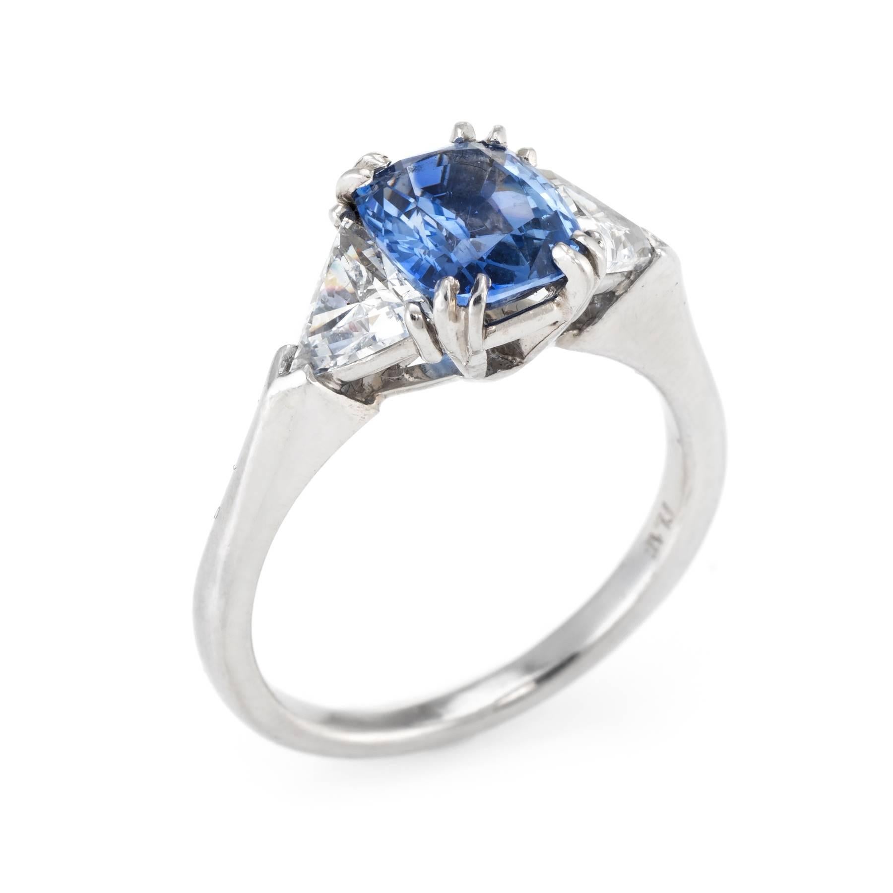 Elegant estate engagement or right hand ring, crafted in 900 platinum. 

Cushion cut sapphire measures 8mm x 6.5mm (estimated at 1.75 carats), accented with two estimated 0.37 carat trillion cut diamonds (total diamond weight is estimated at 0.75
