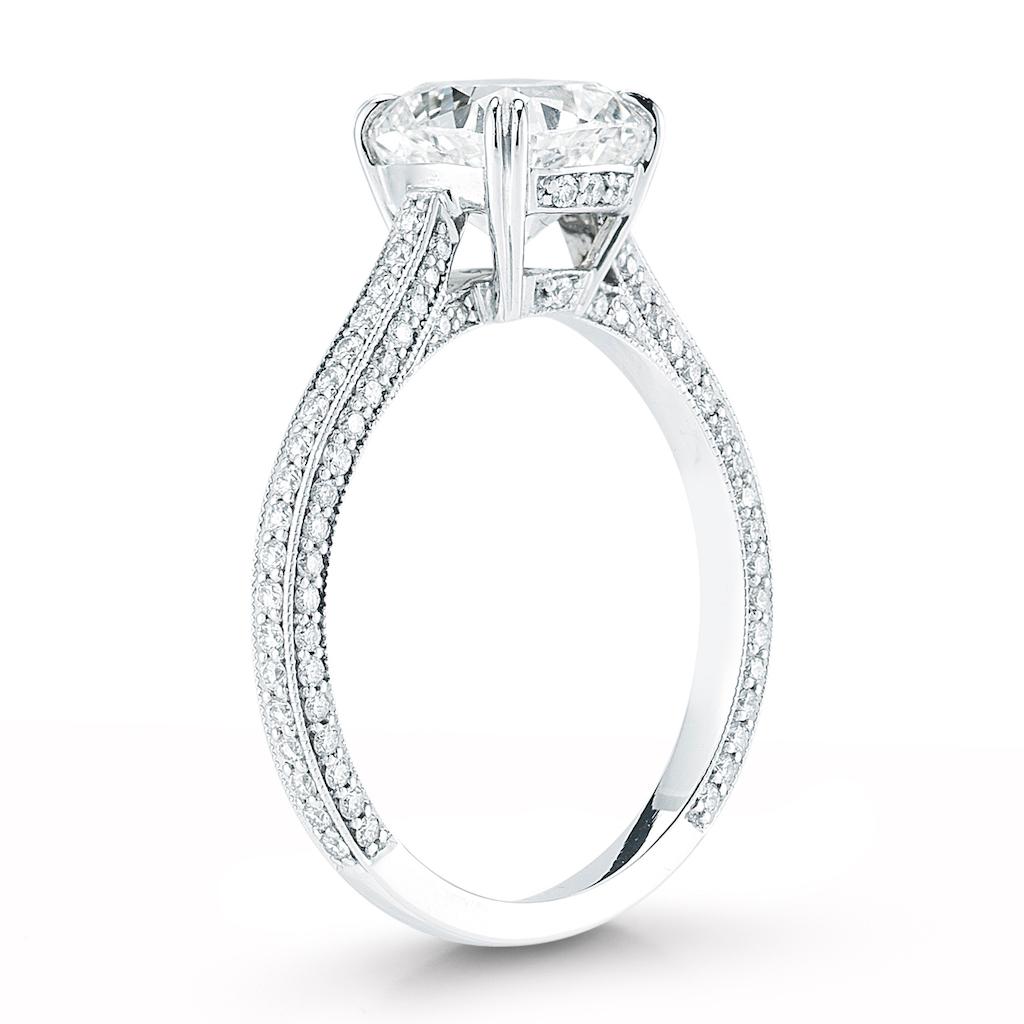 This diamond ring features a cushion cut center stone and a micro pave band. The center stone is available in all sizes, colors and qualities. Setting available in platinum, gold, white gold, and rose gold. 
Presented here is a beautiful handmade