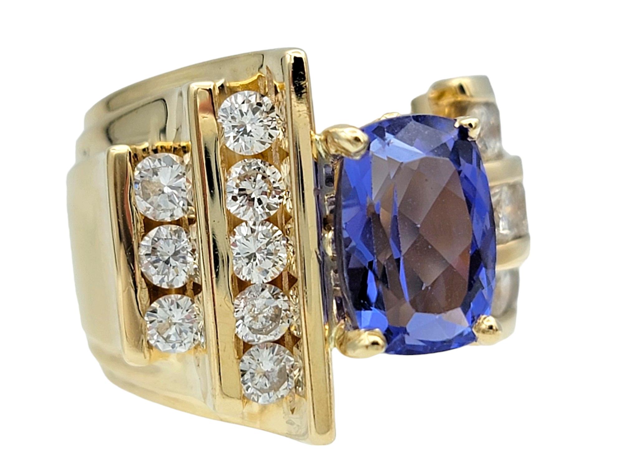 Misura dell'anello: 7,5

Abbandonati alla squisita bellezza di questo esclusivo anello cocktail con tanzanite e diamanti, realizzato in lussuoso oro giallo 14 carati. Il centro è costituito da una splendida pietra tanzanite con taglio a cuscino, che