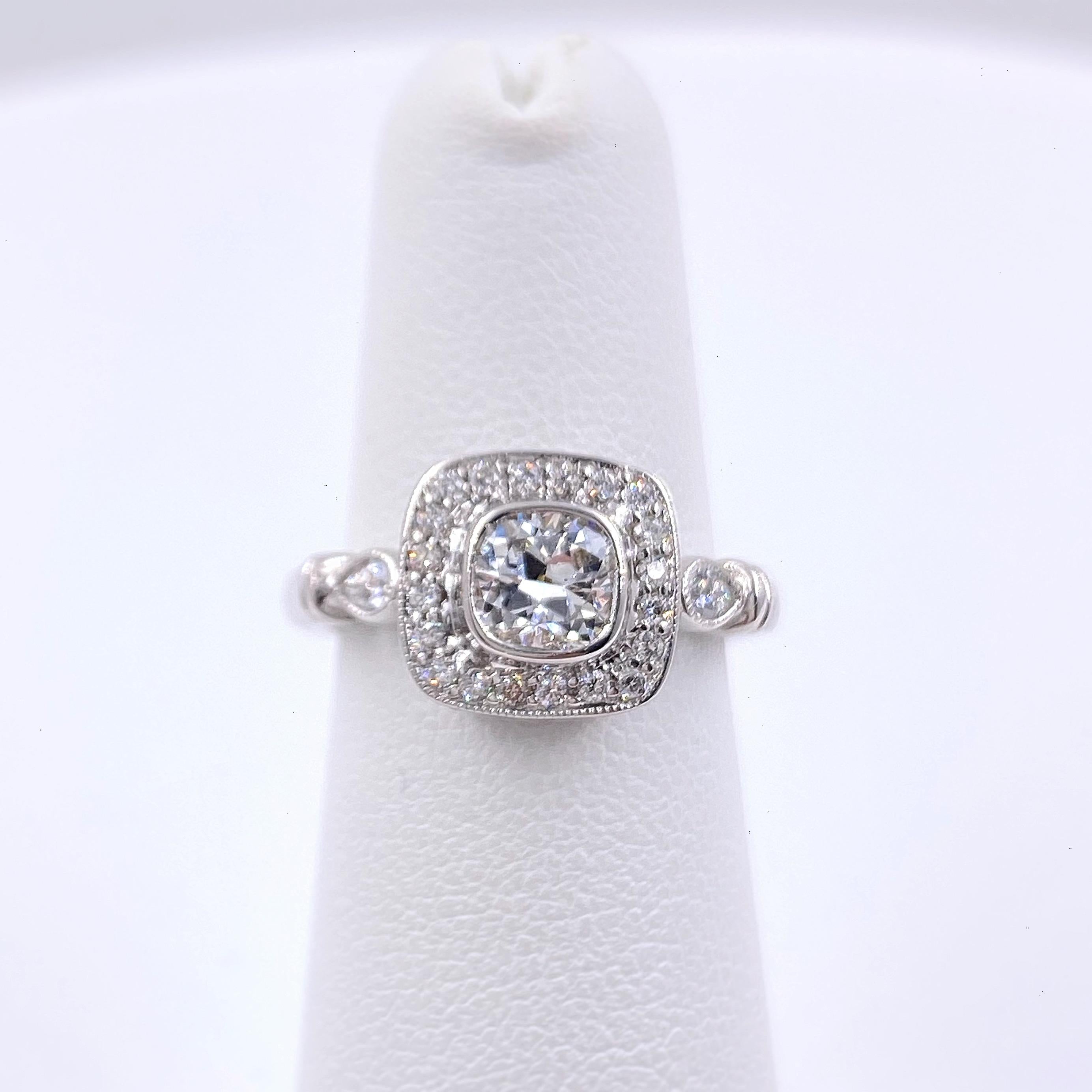 Diamond Engagement Ring
Style:  Bezel Set with Halo Ring
Metal:  18kt White Gold
Size:  6 - sizable
TCW:  1.20 tcw
Main Diamond:  Cushion Diamond 0.70 cts
Color & Clarity:  G - VS2
Accent Diamonds:  38 Round Brilliant Cut 0.40 tcw  G-H VS2-SI1 & 2