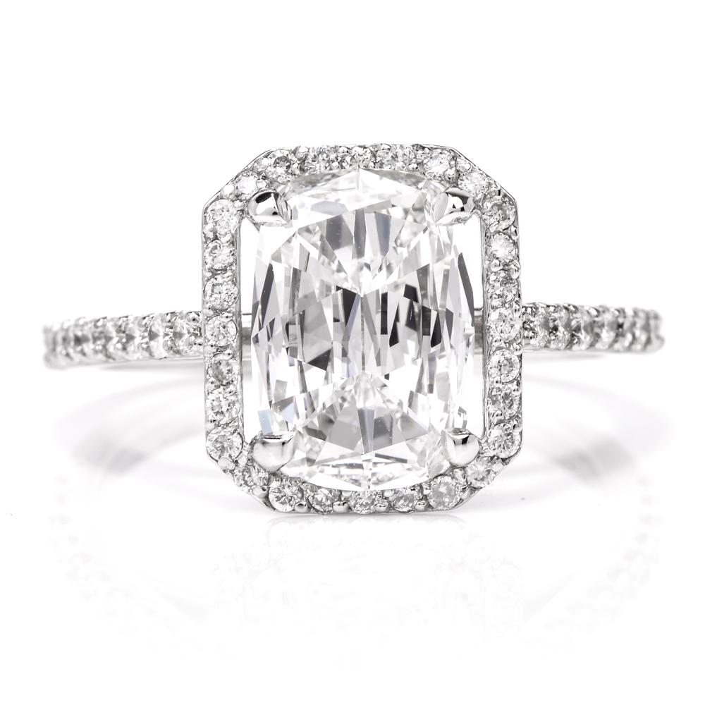 This beautiful diamond ring is crafted in solid platinum. Displaying a prominent four prong set cushion cut diamond approx. GIA 2.06 carats, F color, VVS2 clarity. Surrounded by a halo of pave-set round-cut diamonds approx. 0.65carats, G-H color,