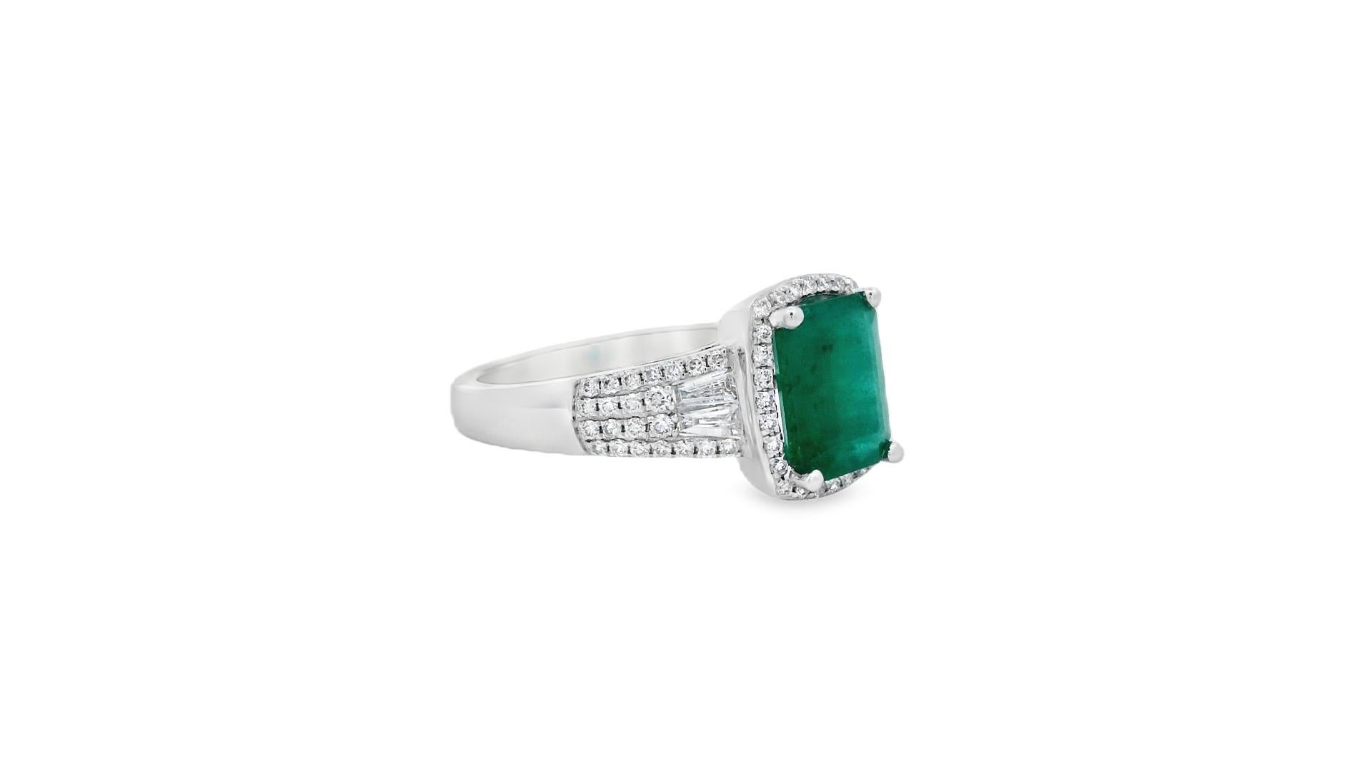 Bold and elegant, this cushion-cut emerald and diamond ring is set in polished 14K white gold with a luminous blend of baguette and round brilliant diamonds. The 8x6mm natural emerald, weighing 1.45 carats, is framed by a glittering halo of round