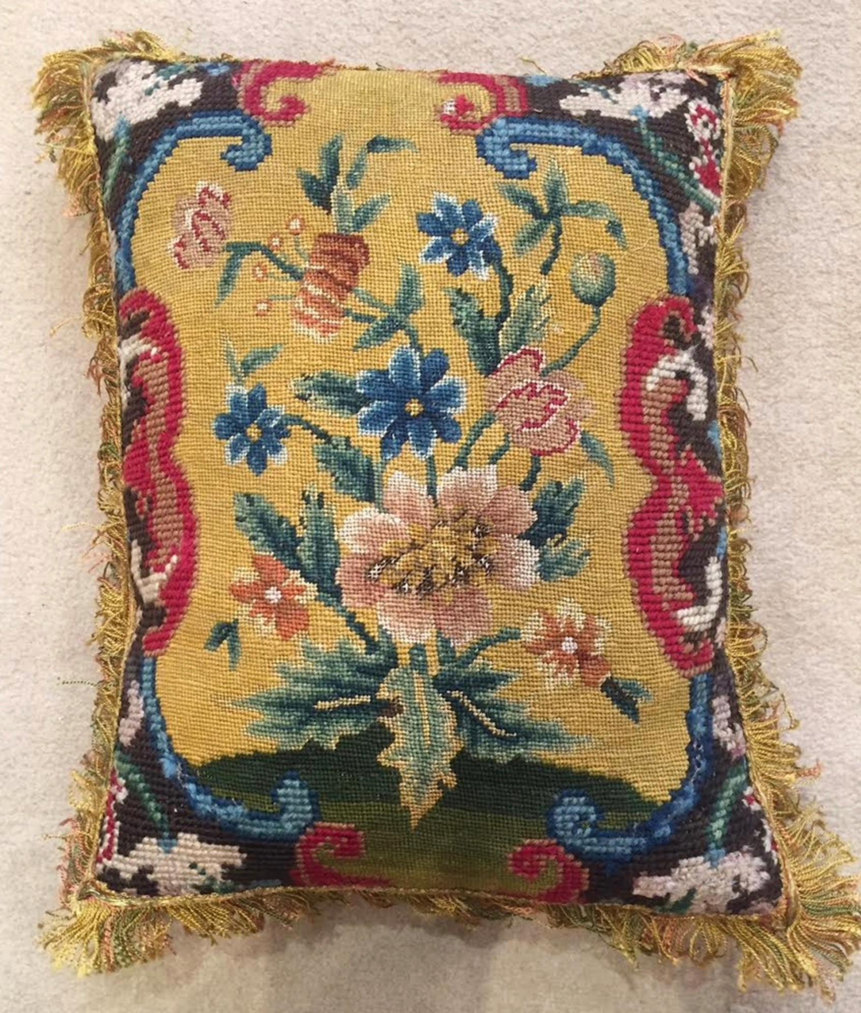 A very charming mid 18th century French needlework panel, depicting a collection of flowers and foliage, with a mustard yellow background. Retaining beautiful colours - now mounted as a cushion.