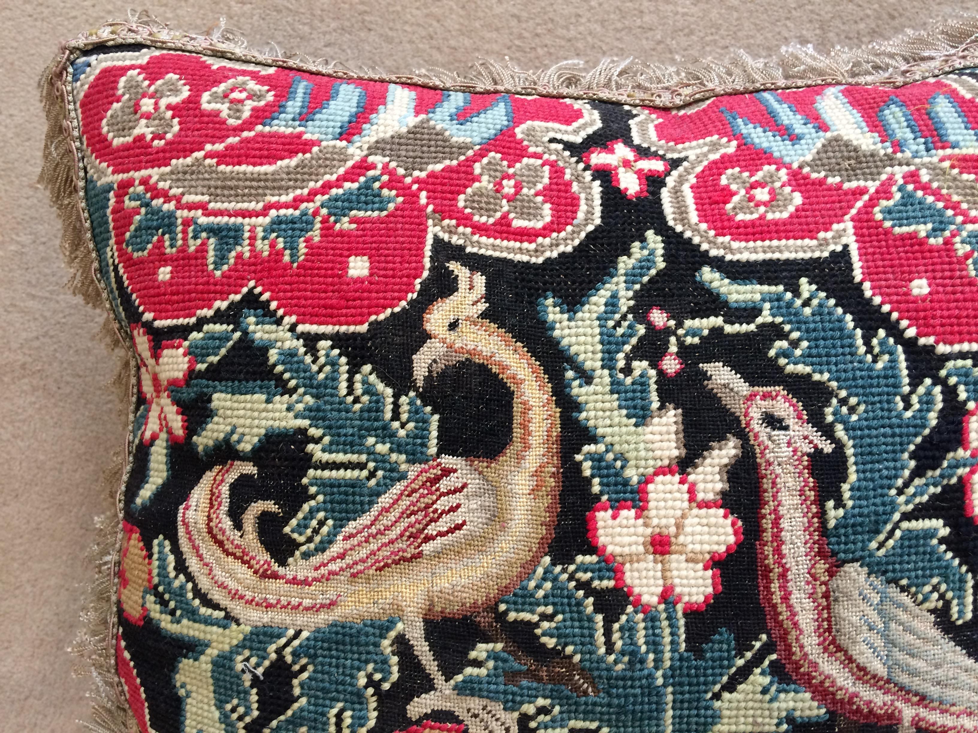A cushion of mid-18th century French needlework with a black ground with exceptionally fresh colors.