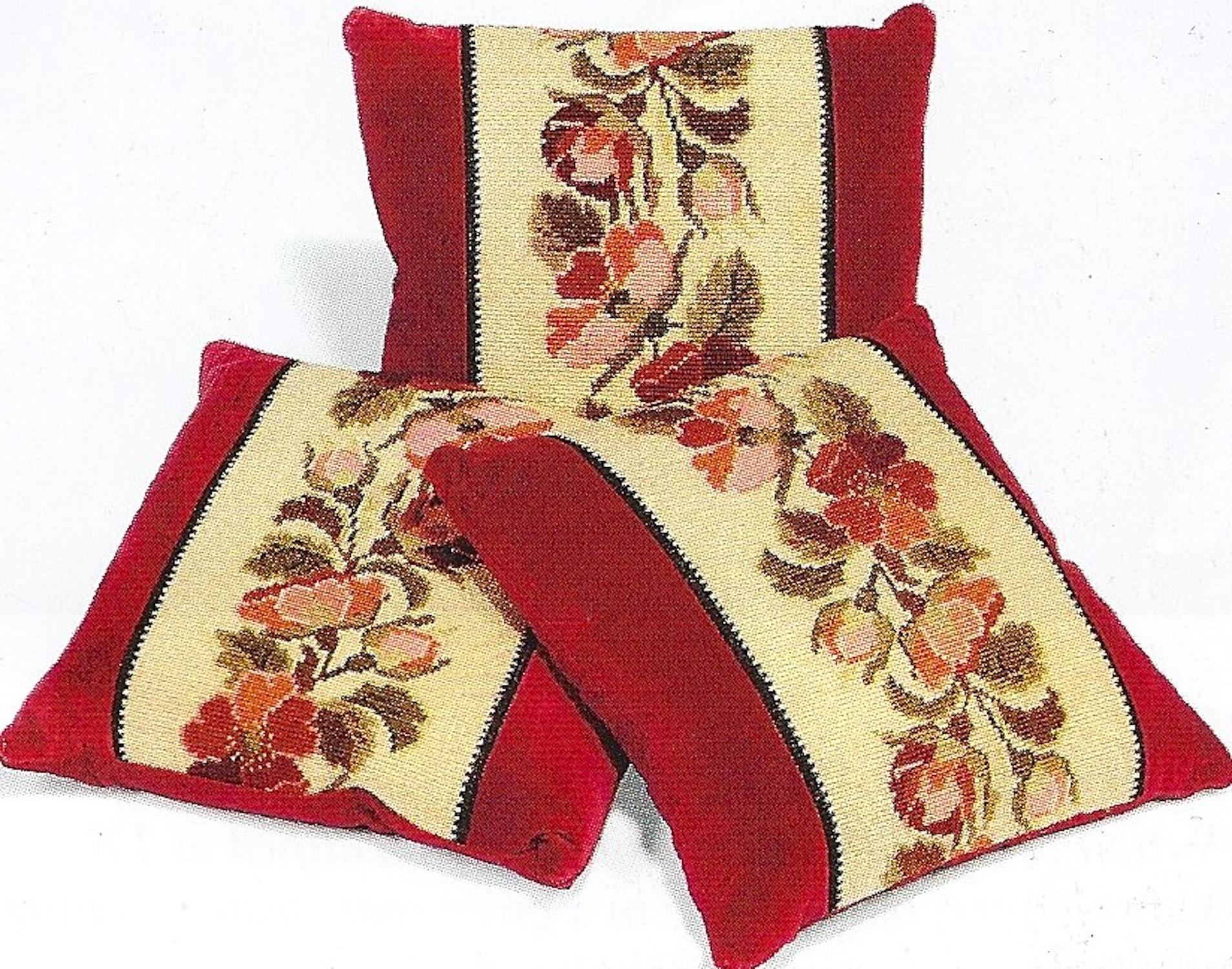 The pillows or cushions are made from late 19th century crimson velvet. This has been applied with 19th century needlework panels. The needlework has a cream ground embroidered with pink and green floral sprays. The condition is excellent. There are