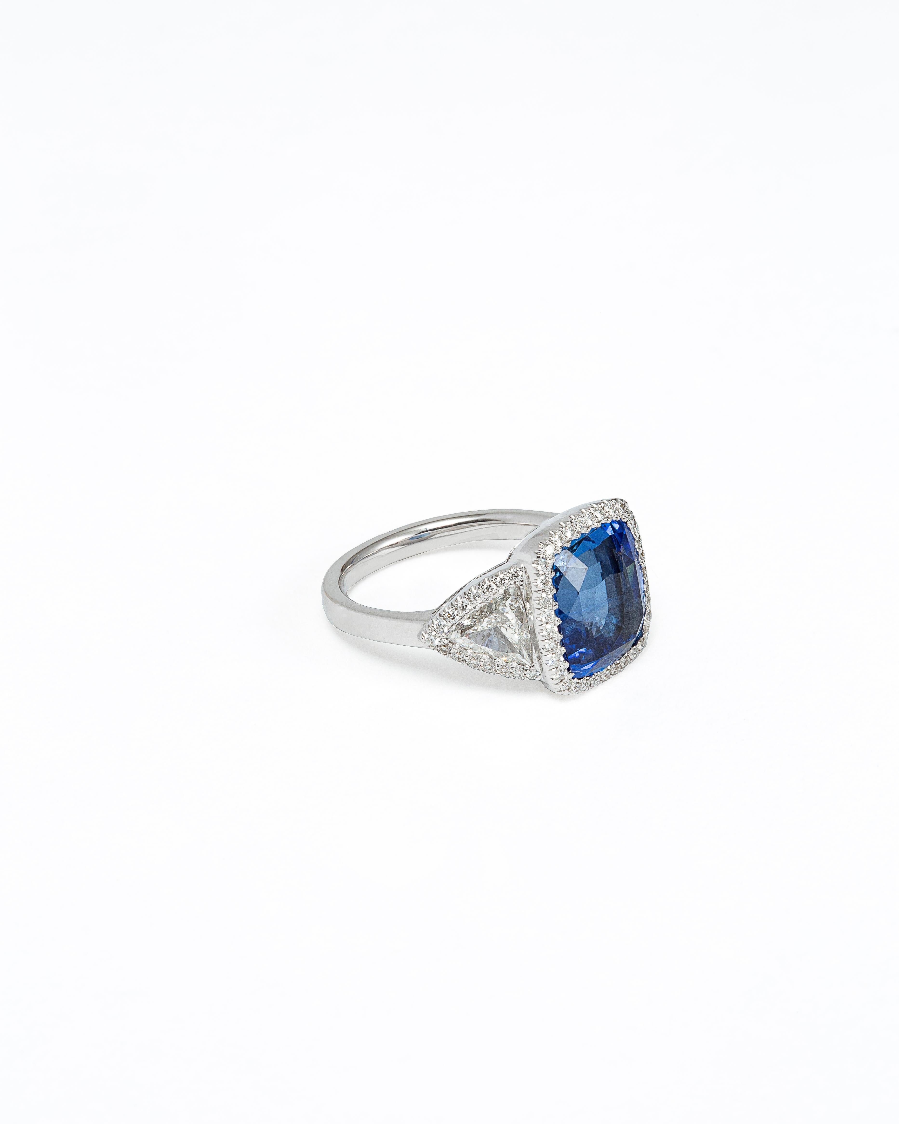 Ring made by our craftsmen in Antwerp. The ring is made of gold 18K, set with a central Ceylon deep blue sapphire of 6.50 Carats. We brought ourselves the sapphire from Sri Lanka and mounted it here in Belgium. The ring is also set with two triangle
