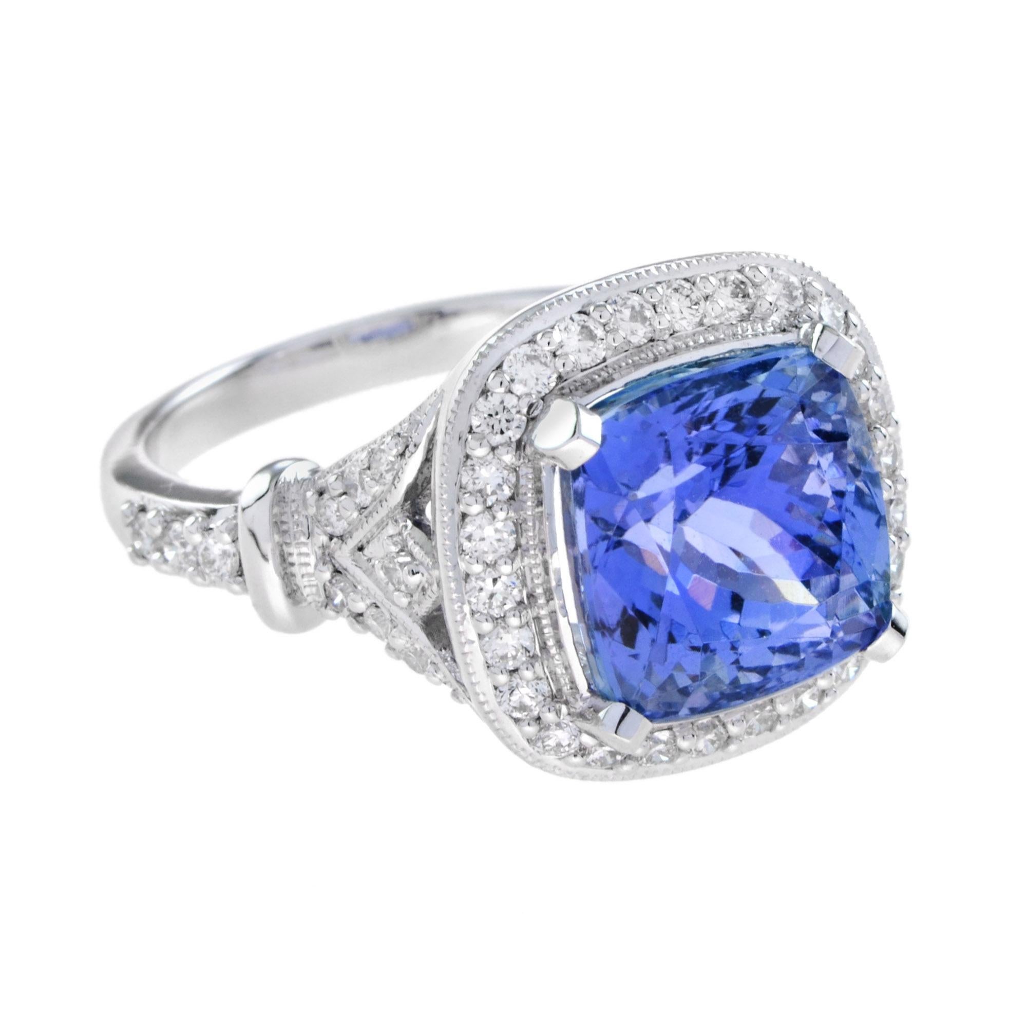 Dieser elegante Ring zeigt einen blau-violetten Tansanit von 6,68 Karat, der von einem Halo aus farblosen Diamanten im Rundschliff umgeben ist. Zusätzliche Diamanten säumen den dreifach geteilten Schaft und unter der Galerie und vollenden die