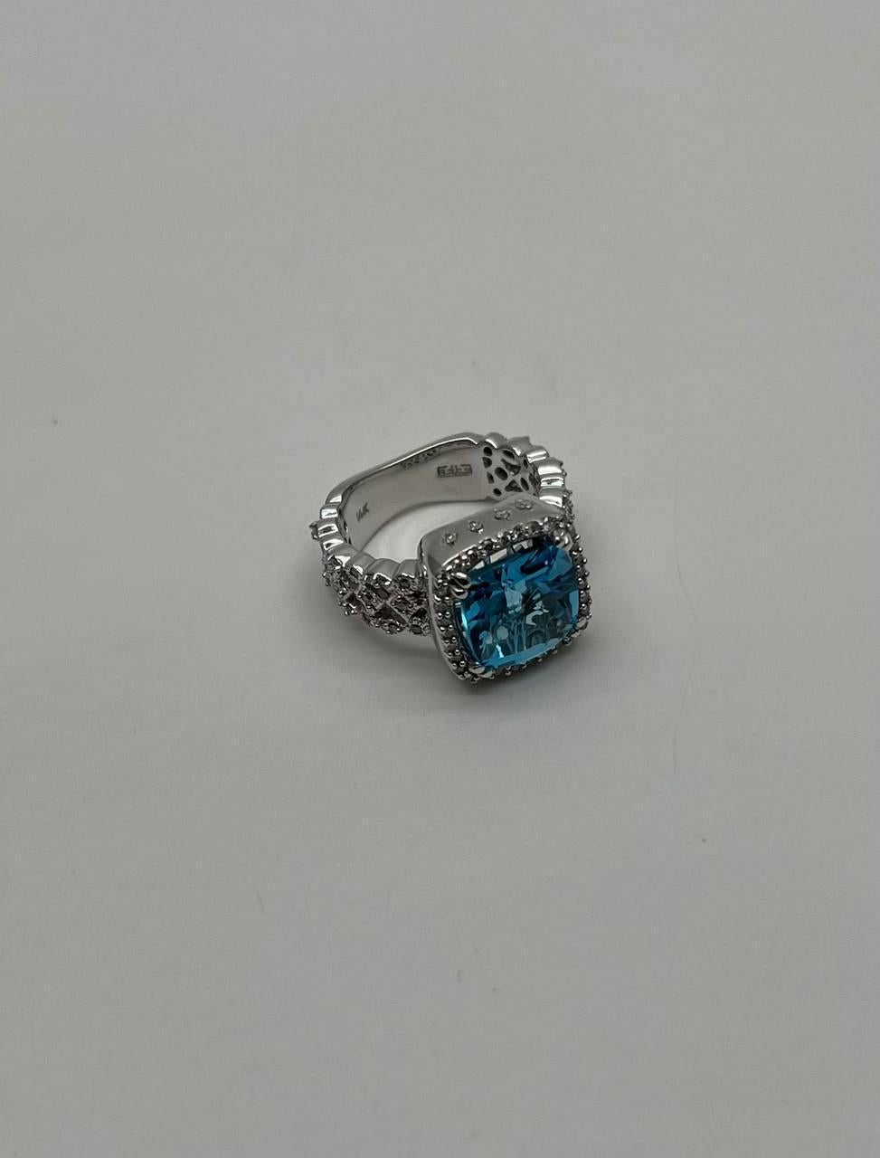 A striking Blue Topaz and Diamond Ring, featuring a magnificent 5.03ct Cushion-cut Blue Topaz set in 14k White Gold, further adorned with 0.54ct of White Diamonds.