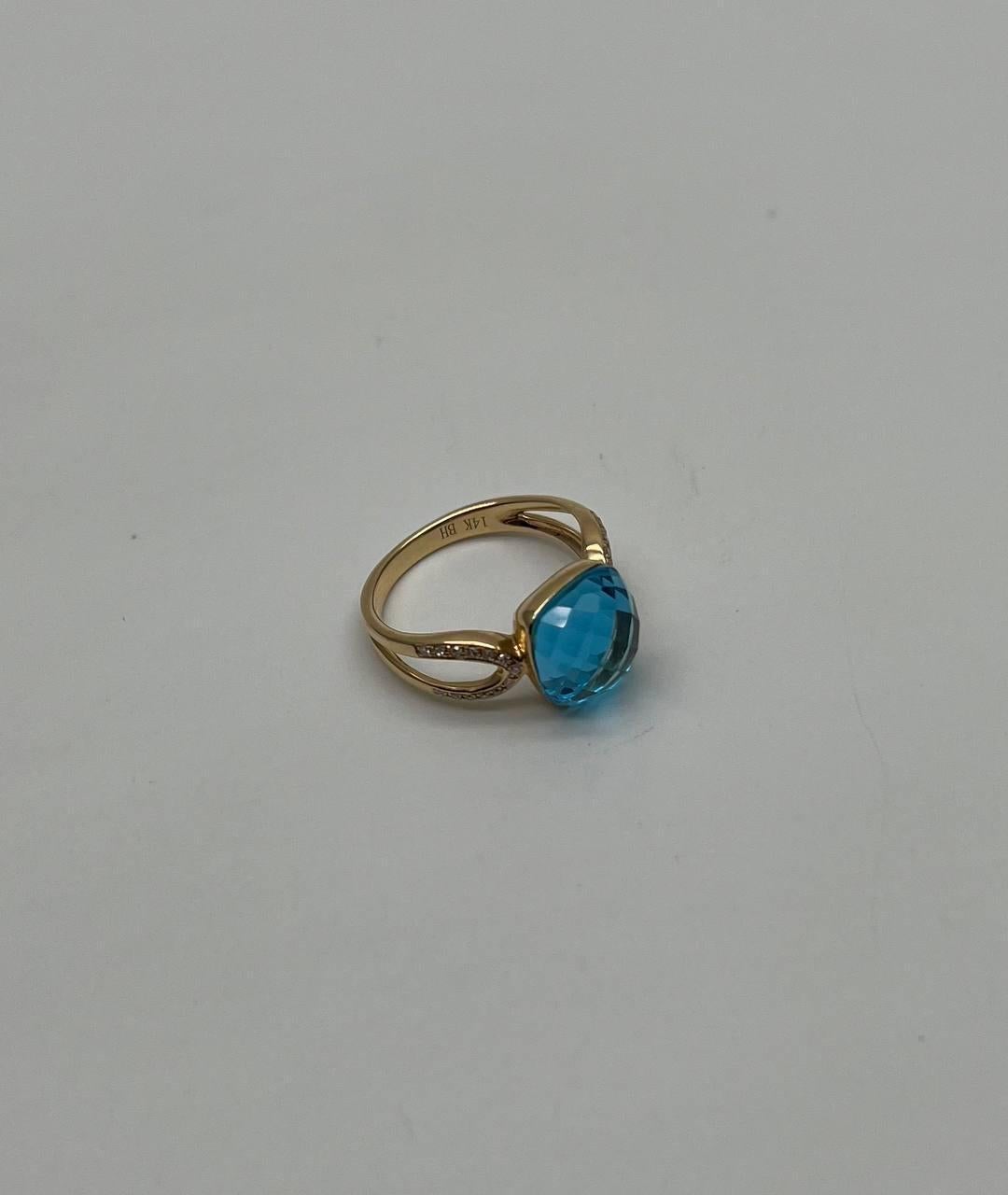 Elegant and Timeless. Set with a Cushion-Cut Swiss Blue Topaz.  Accented by Delicate Gold Detailing. 14K Yellow Gold. 0.10 CTW Diamonds. 6.50 Cts Blue Topaz.