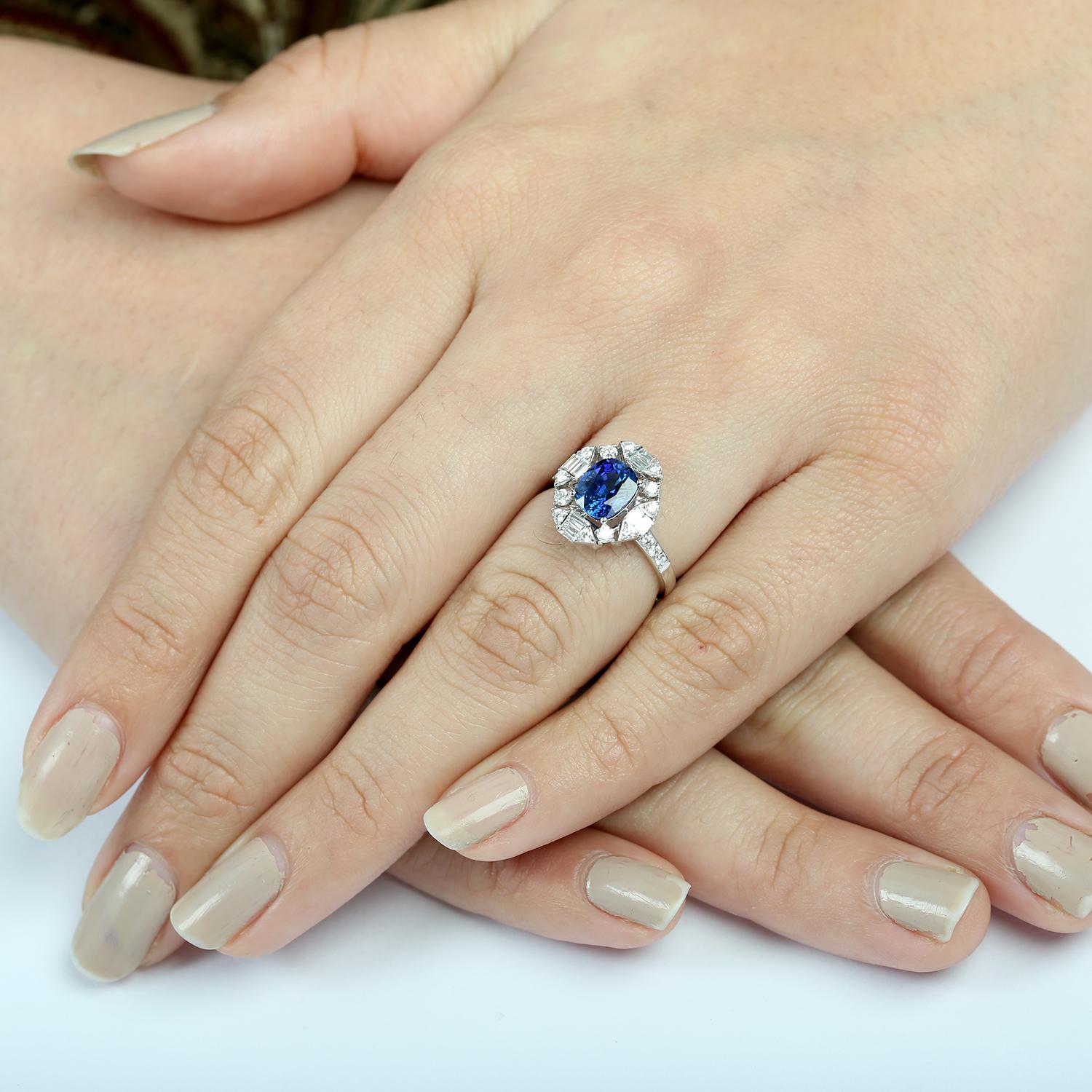 18KT Weißgold Cushion Ceylon Blue Sapphire Ring mit Diamanten
Raffiniert und strahlend präsentiert sich dieser Ring mit einem lebhaften kissenförmigen blauen Ceylon-Saphir, der von funkelnden Diamanten umgeben ist. Das aus poliertem 18-karätigem