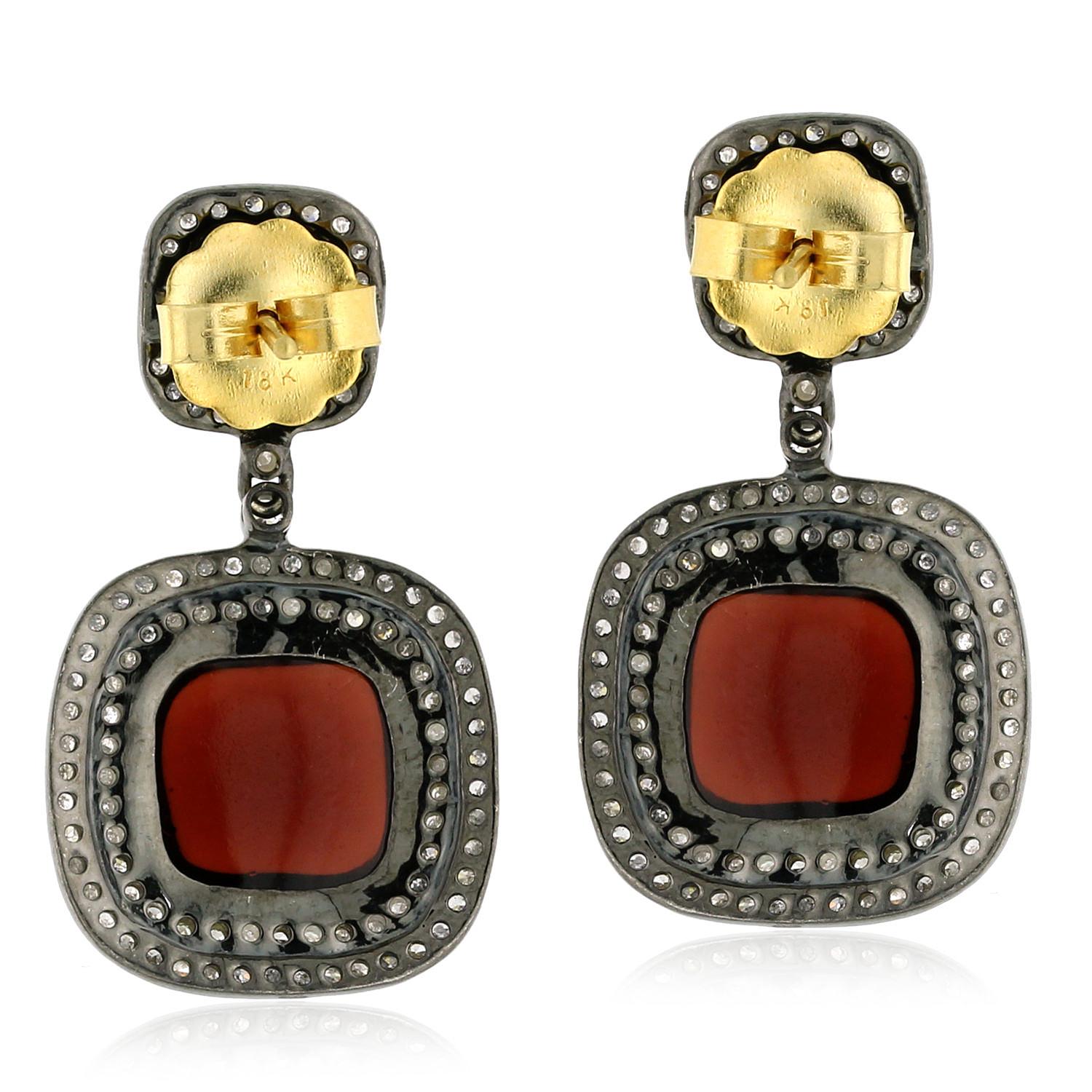 Add a pop of color to your jewelry collection with these beautiful Cushion Shaped Garnet & Tsavorite Earrings. Expertly crafted in 18k gold and silver, these earrings feature cushion shaped garnet and tsavorite gemstones, set in elegant and timeless