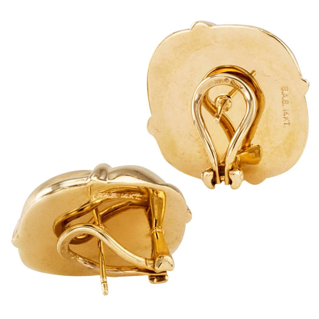 Cushion shaped button gold earring. Crafted in 14-karat yellow gold, the slightly domed designs center upon an X shaped motif in relief, framed by alternating brushed and high polished textures on the gold. Their simplicity elevates their beauty to