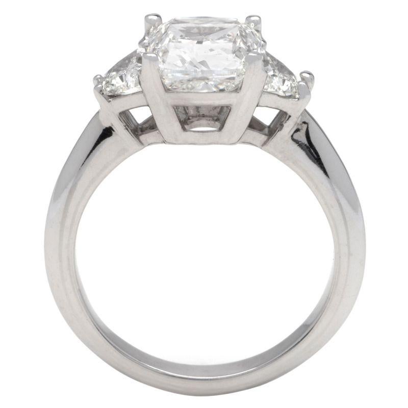This ring features a three-stone design of G color, VS1 clarity, and .75ct side diamonds set in 14K white gold. The center diamond is a 3.03ct I color SI1 clarity Cushion cut diamond. Available in 14k, 18k white gold, yellow gold, rose gold, and