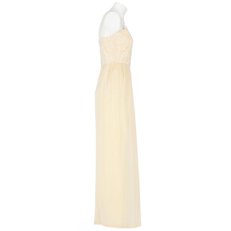 A.N.G.E.L.O. Vintage - italy

Splendid custard silk wedding dress. It features thin shoulder straps, a white lace bodice with floral decoration, wide skirt and lateral zip closure. The item is vintage, it was produced in the 60s and is in very good