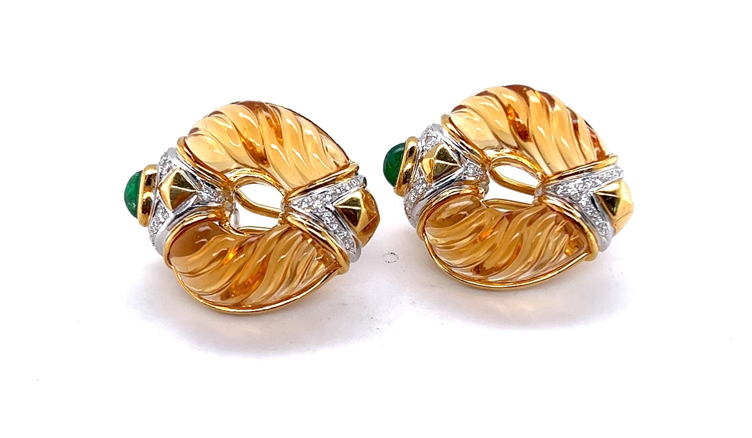 Custom made 14kt yellow gold omega back earrings featuring hand carved Citrines, emerald cabochons and diamonds set in 18kt white gold. The diamonds weigh approximately .24 carats and possess an average of G-H color/ VS2-SI1 clarity. 

These