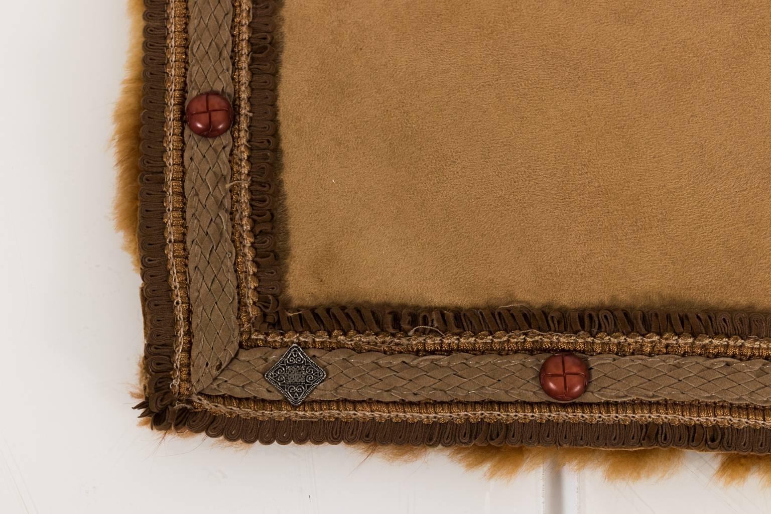 Contemporary alpaca throw blanket with faux suede lining and leather trim with metal stud details.
 