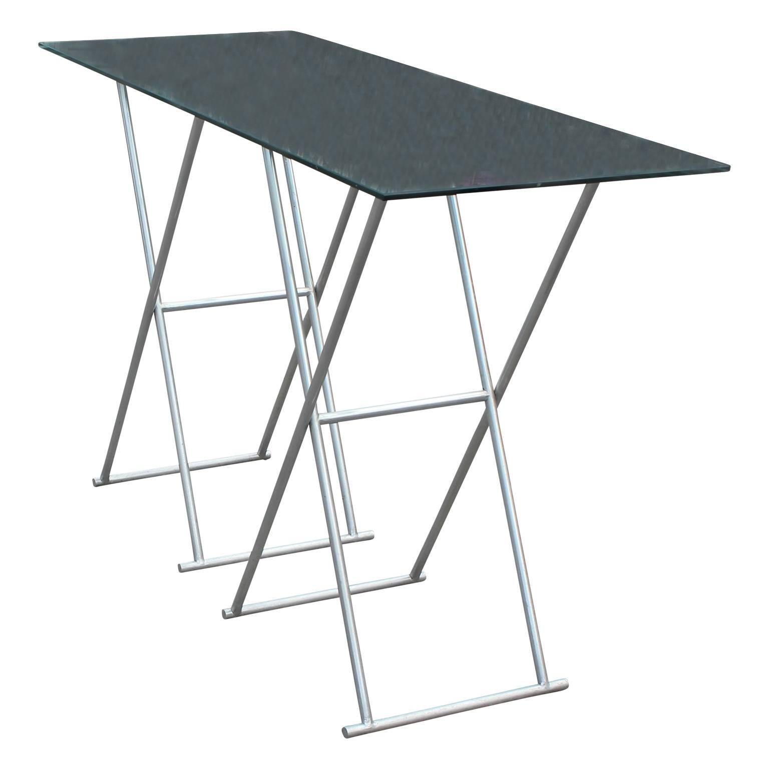 Custom aluminum folding console table with leather straps. Chrome and leather strapped pedestals can be adjusted to suit your desired length. Measure: Length of the glass top is 54 inches.