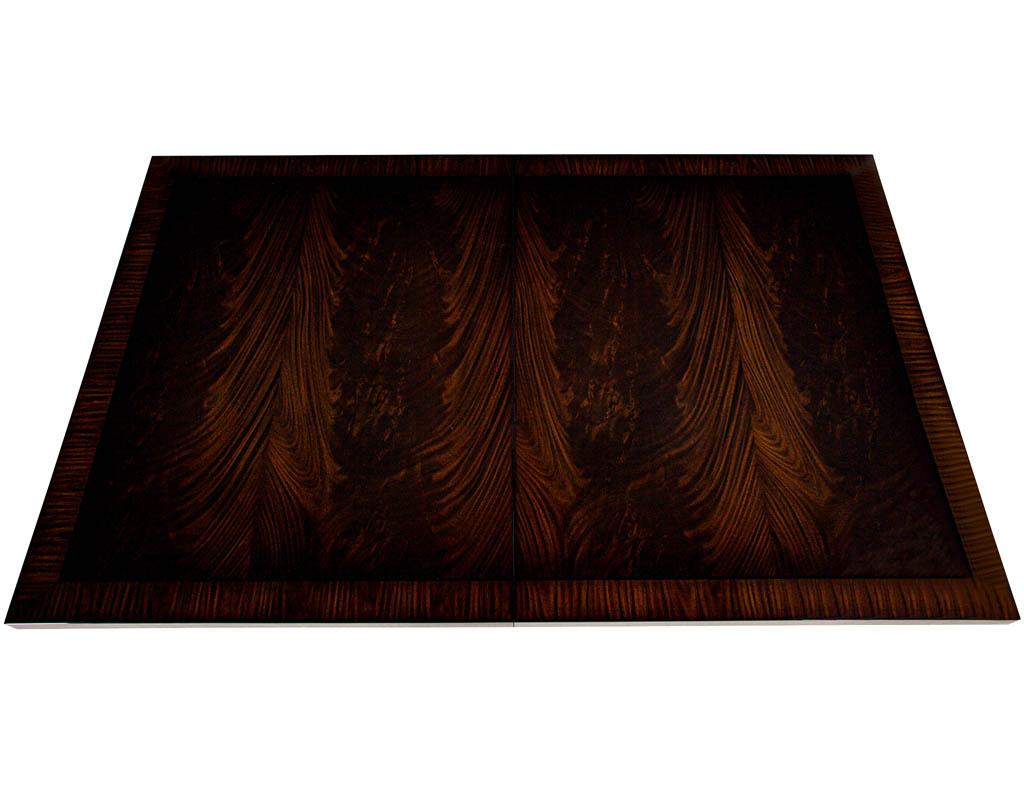 Custom Art Deco Inspired Flame Mahogany dining table. Featuring magnificent flame mahogany veneers with rosewood edge banding. Completed in a rich high gloss lacquered finish. Table extends with 2 leaves. Table fully extends to total 109.75