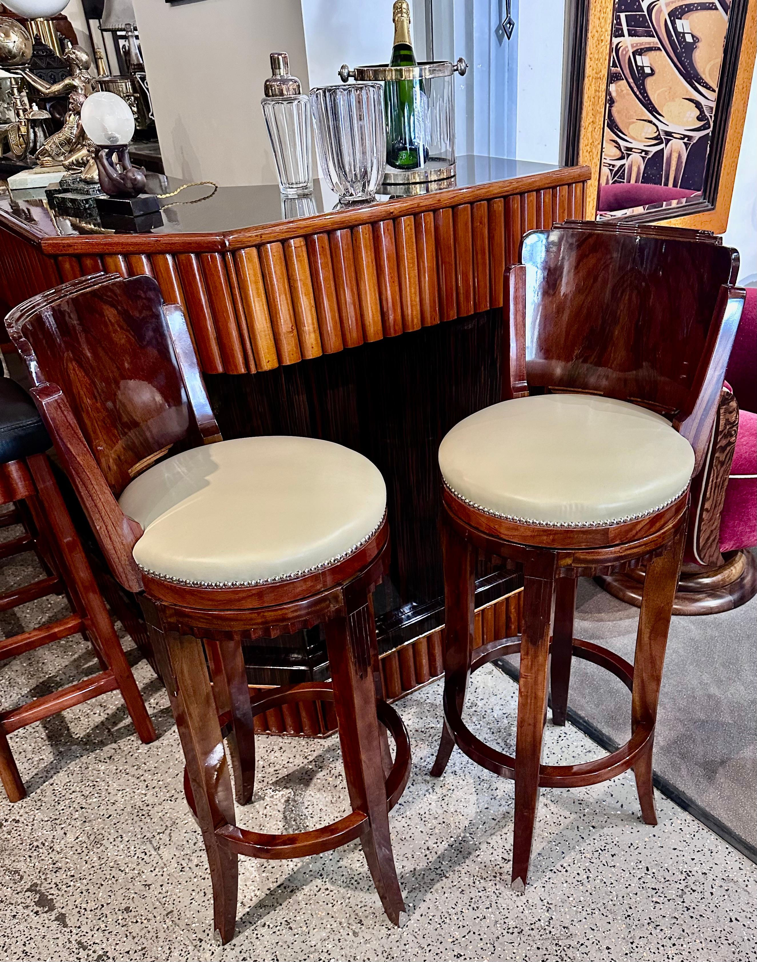 Custom Art Deco swivel wood barstool using exotic woods. Quality materials: French nails used for cream leather upholstery, and subtle contrasting woods pronounce some of the design details with the magnified beveled edge of intense walnut graining.