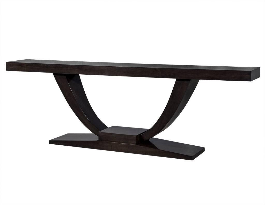 This custom Art Deco walnut console table is absolutely gorgeous. With a large U-shaped base and pedestal, this piece is like a work of sculpture, perfect for behind a sofa or against an entryway wall to really make a statement! Designed and custom