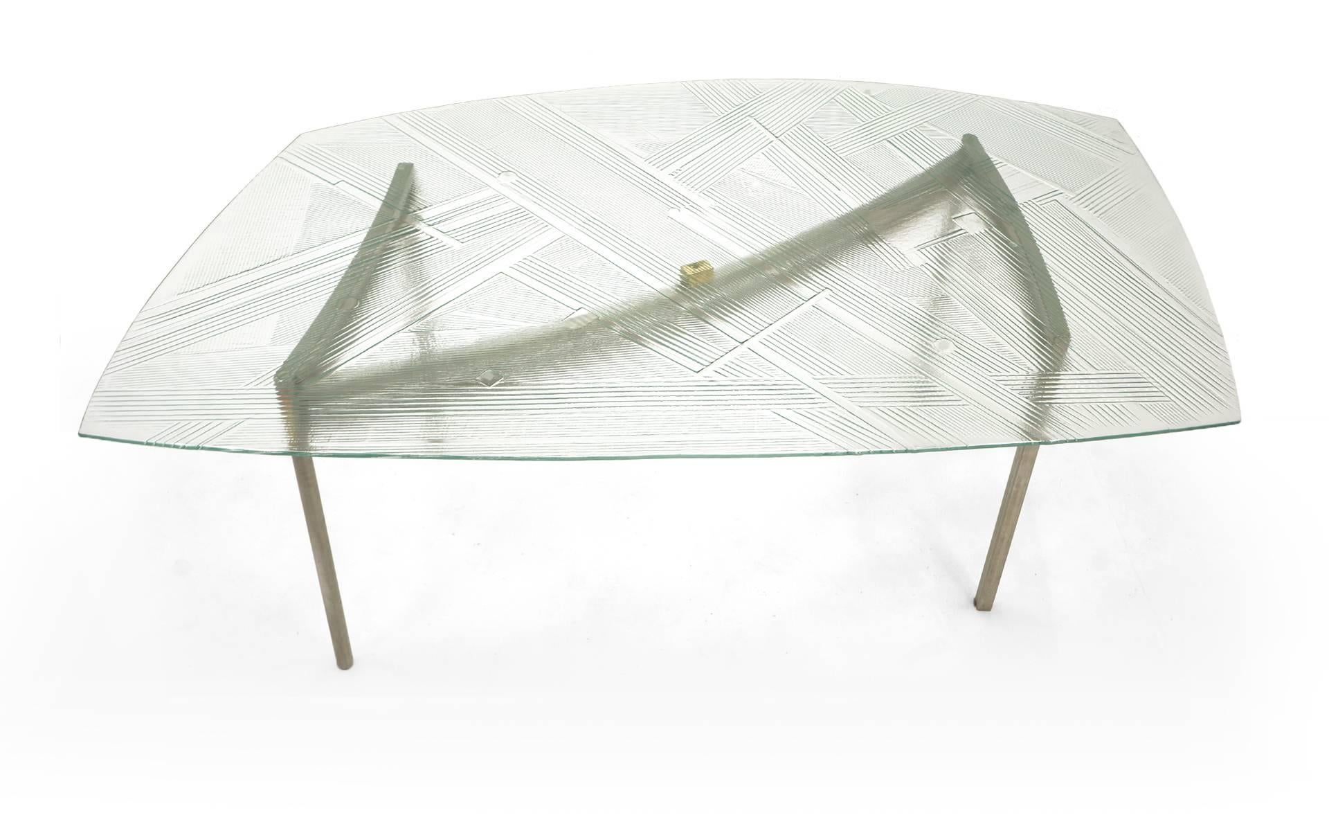 Unique, one of a kind art glass dining table. Tabletop is smooth on top side with designs in the glass on the underside. Substantially thick, but not cumbersome. The glass tope sits on the custom designed aluminum base with small brass square that