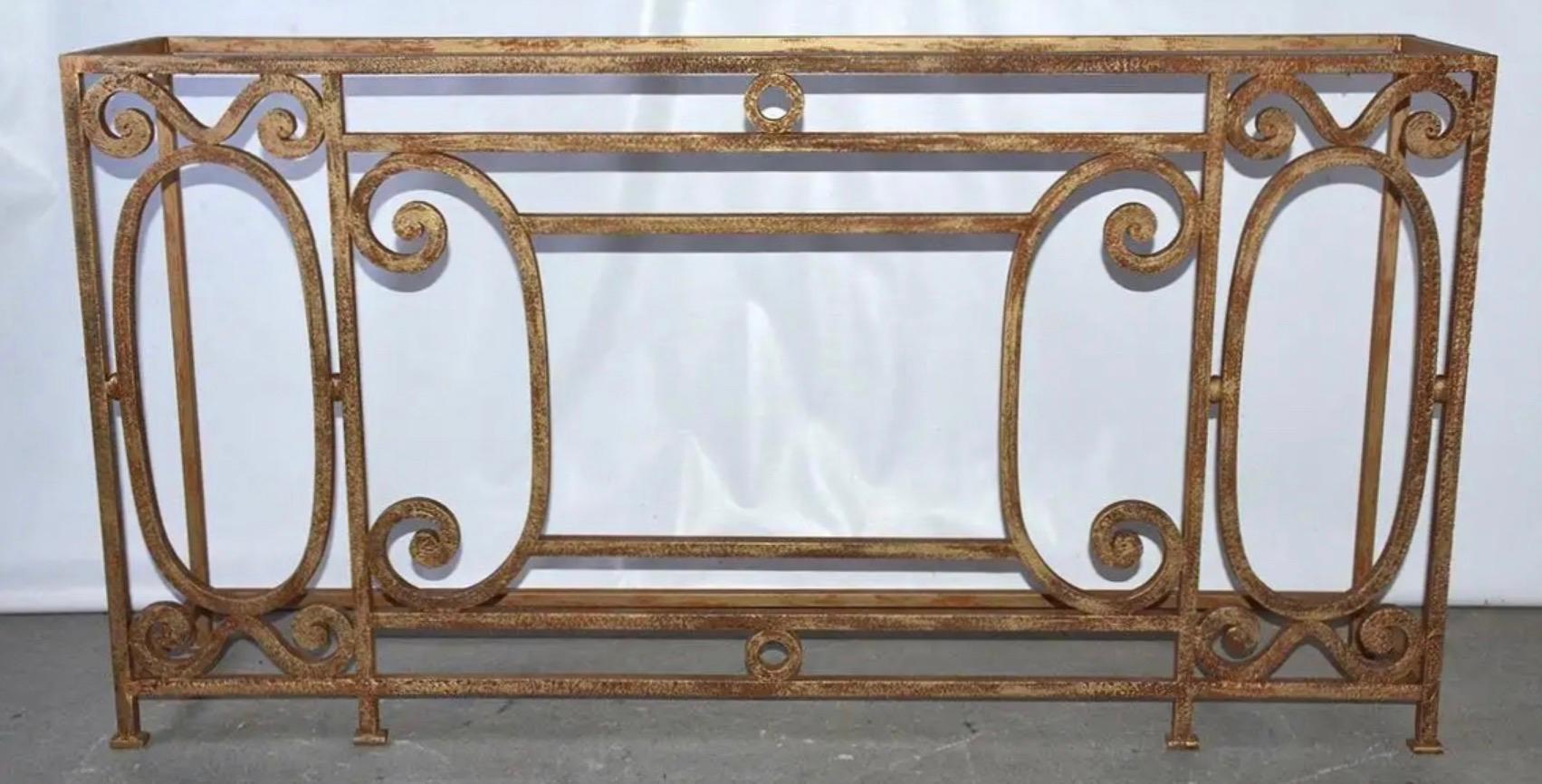 The Baroque style wrought metal console or sofa table has a brushed gilt finish and is handcrafted with elegant scroll-work and detailing. The feet have flat iron pads. The console is newly made from antique fencing. We have additional stock and can