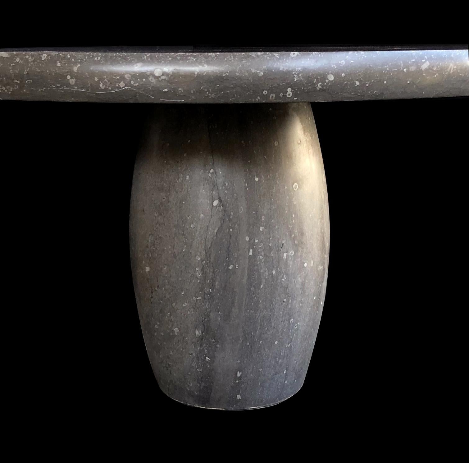 Custom sizes and French Limestone option available; made from Belgian bluestone with a honed finish and embedded with fossils, the table is comprised of a thick round top with bullnose edge and barrel-form support. New with only minimal wear