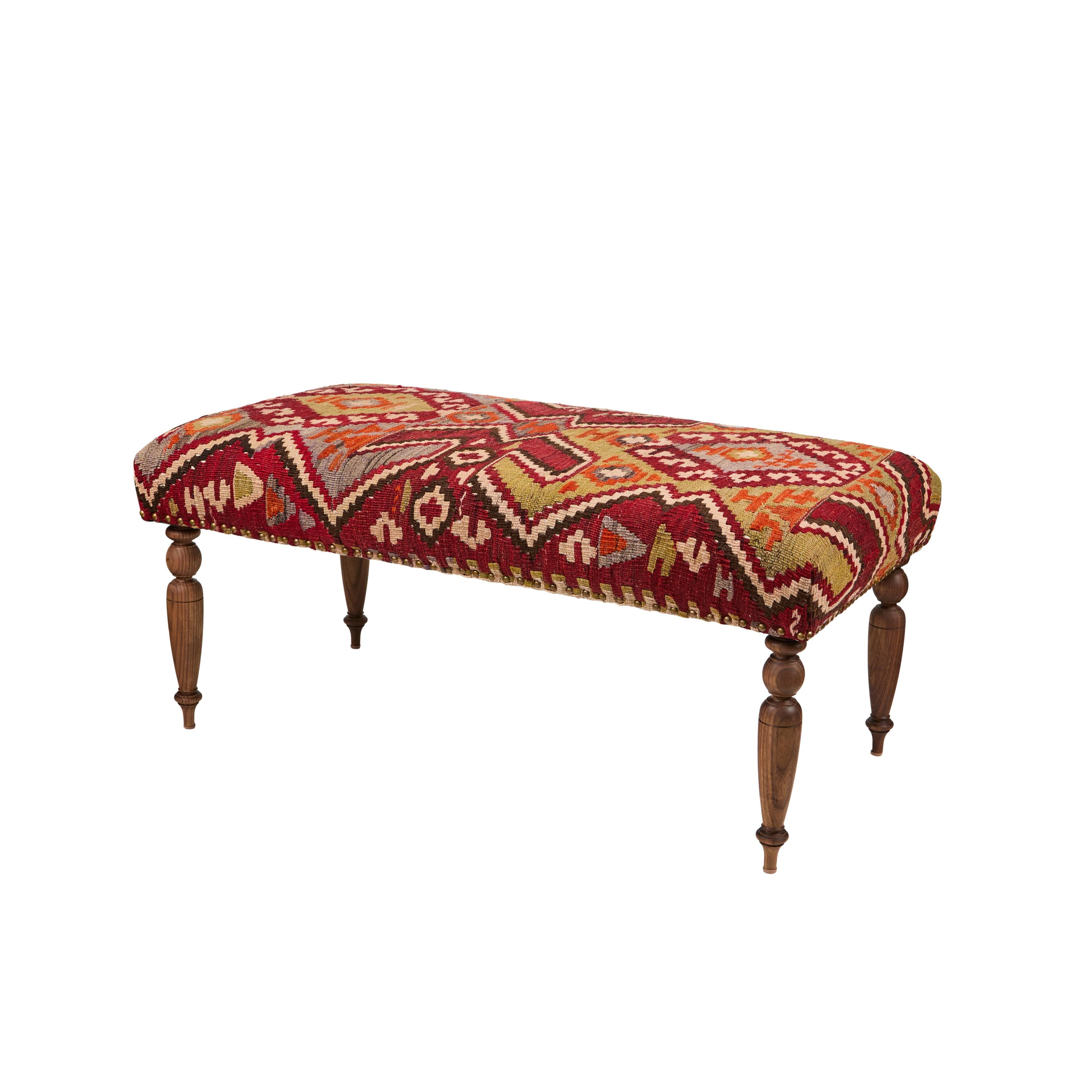 Take a seat on this inviting custom bench that has been newly upholstered in an intricately woven multicolor vintage Turkish rug and is accented with a decorative nailhead trim. It has newly turned walnut wood legs and would make a beautiful
