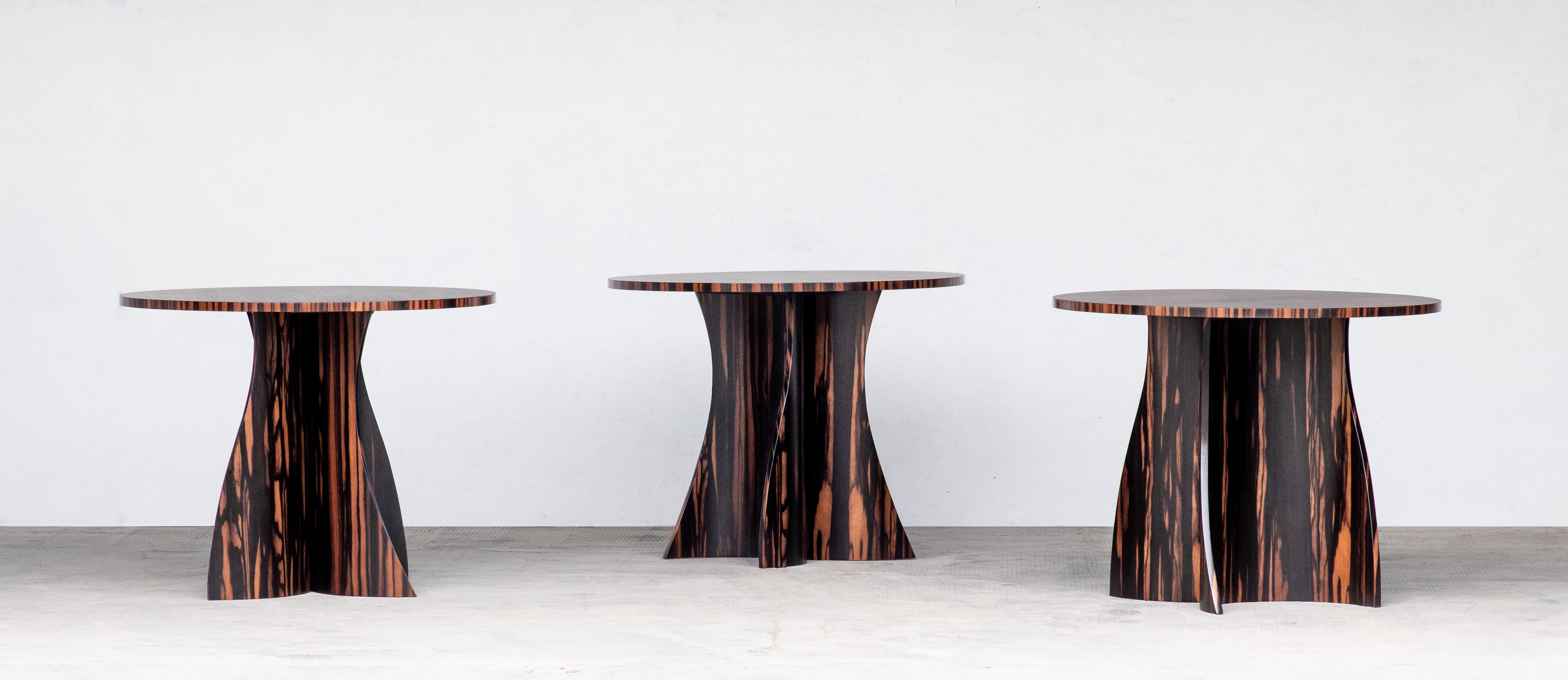 In Stock and available for immediate delivery

The Andino Table features a two-part curved wood base whose shape is seemingly unique from every angle. Shown here in Macassar Ebony, it is customizable in any size or shape top and any