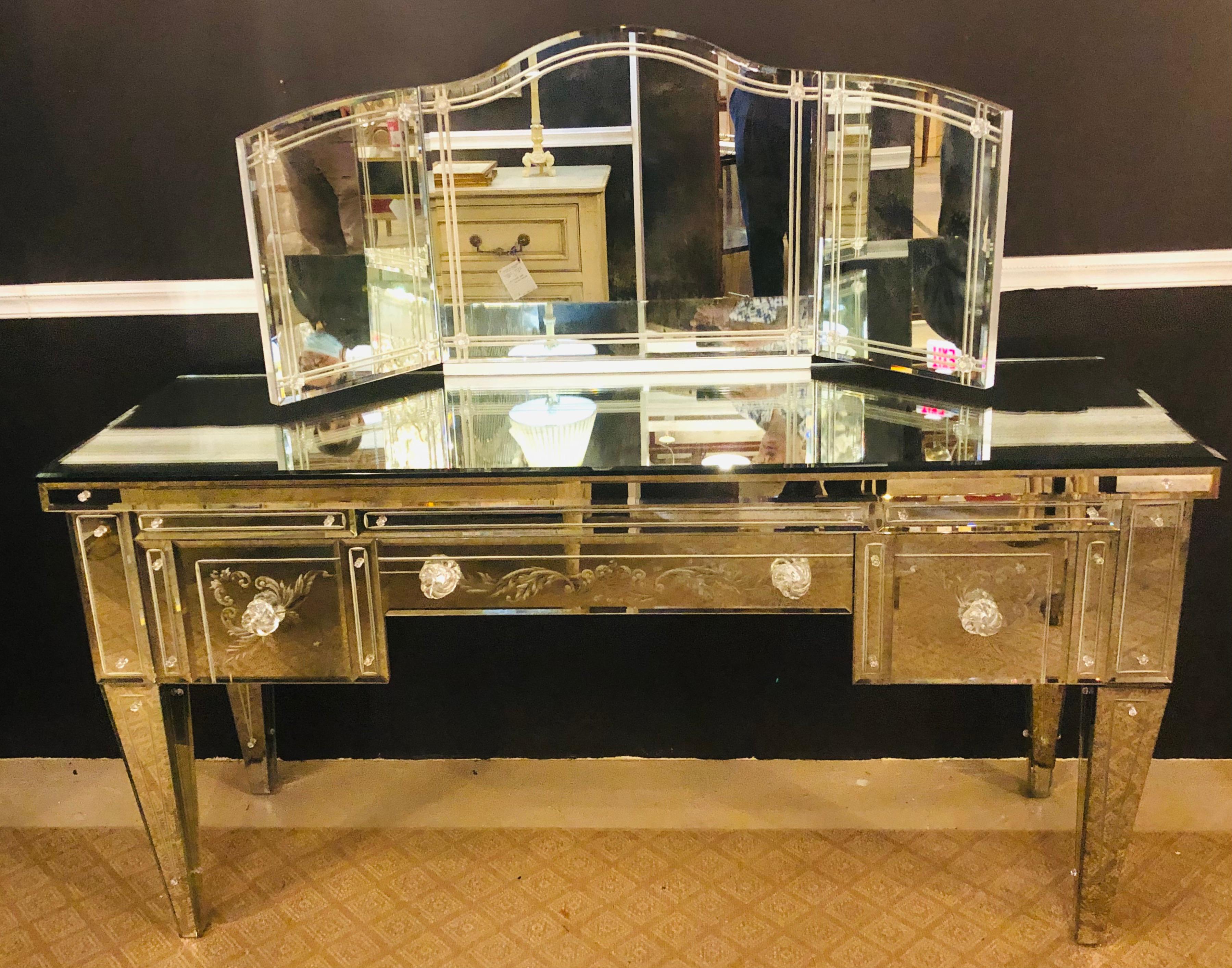 Hollywood Regency beveled and etched glass mirrored vanity desk. Finished on all sides, lined interior having a tri-fold desk top etched mirror measuring: 48 inches wide by 21 inches high. This simply stunning custom made beveled mirror etched glass