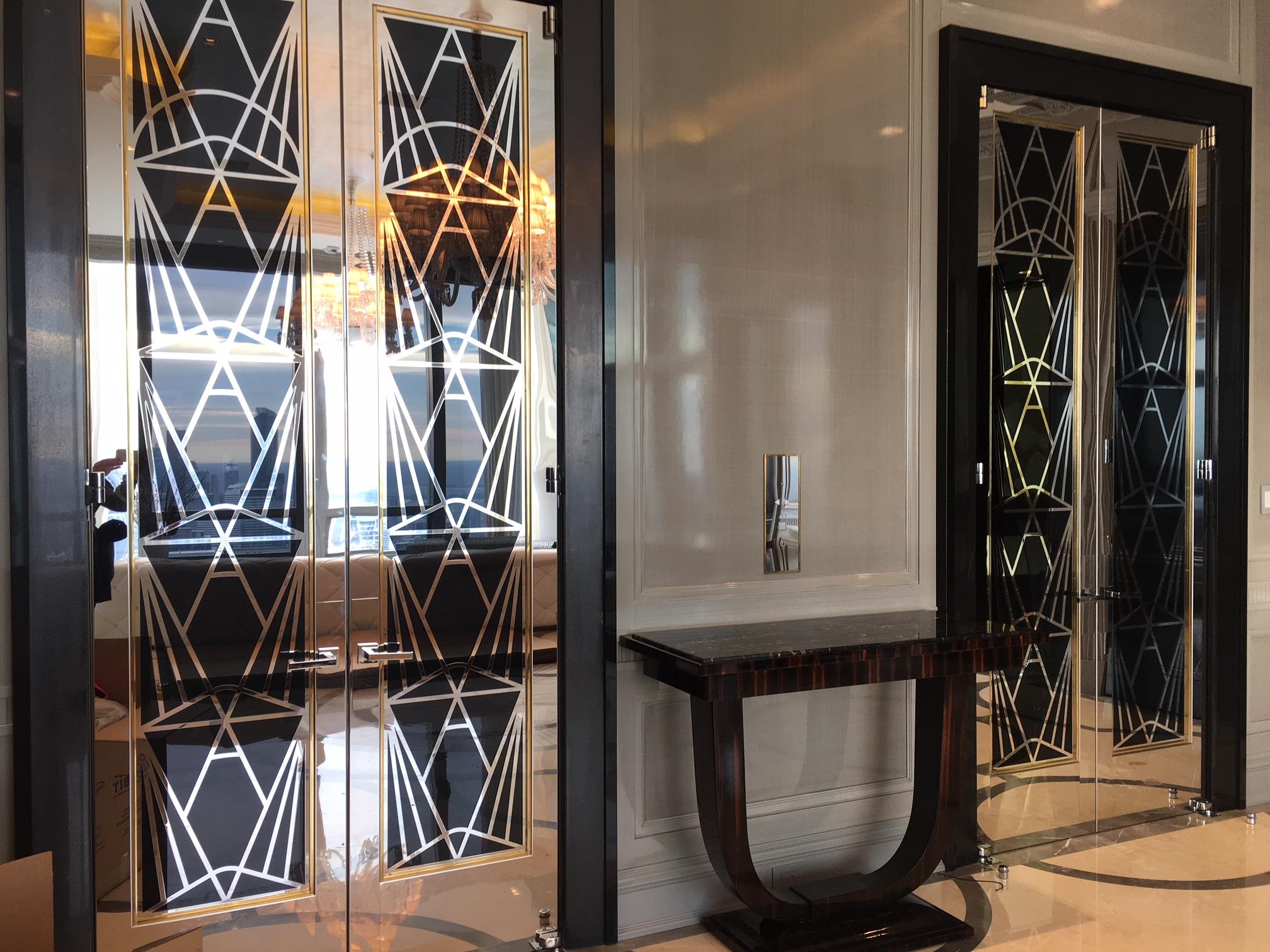 Set of custom Art Deco-style doors designed for a penthouse at the Four Seasons. Installed for one year of use and uninstalled. Doors are finished in laminated glass, polished stainless steel, and have polished bronze glass stops. Stainless steel