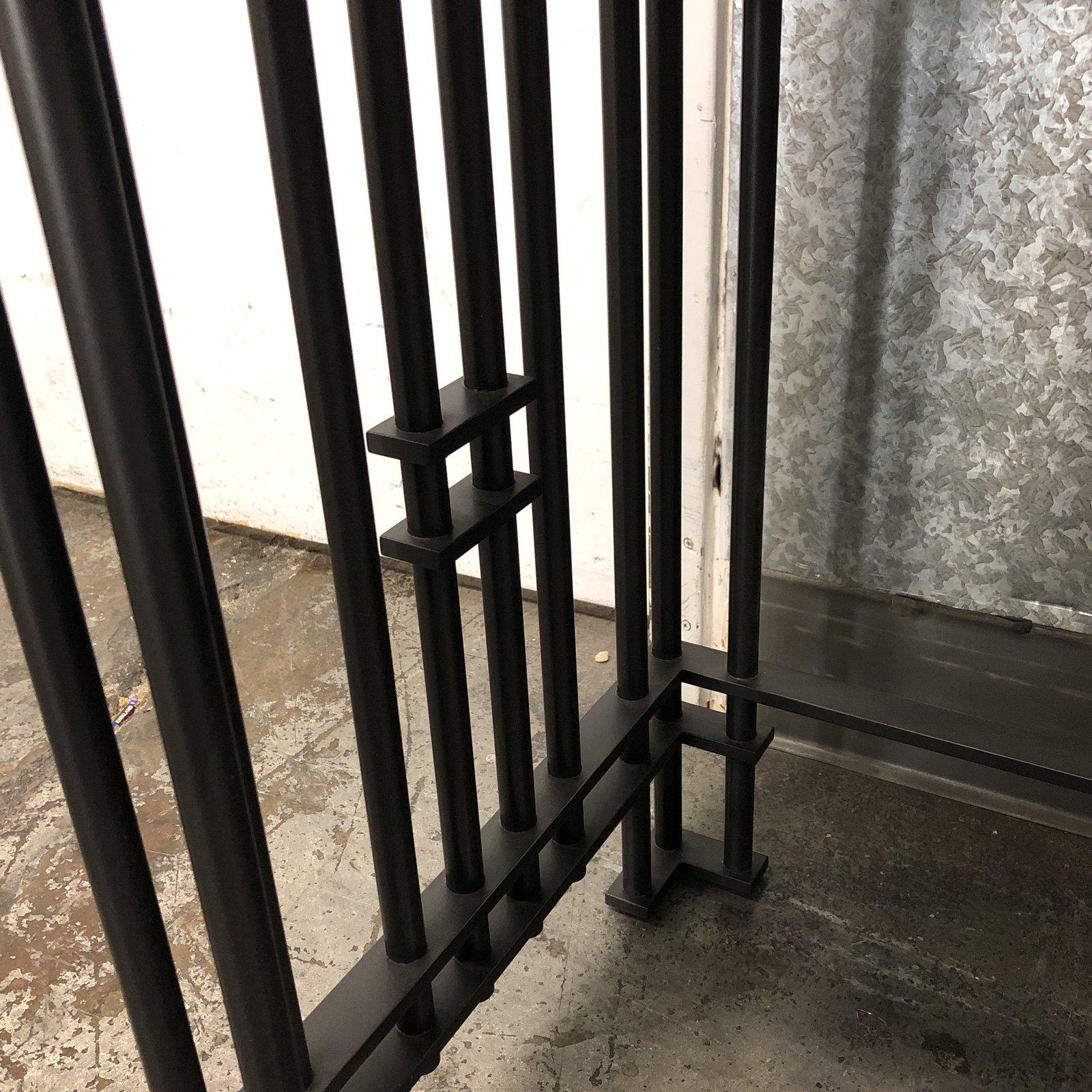 This is a custom black stone on black iron console table. Iron bars intersect in latticework reminiscent of Art Deco styles, if not for the black on black color scheme, and solid, sharp edges echoed in the stone top. A formal, and exquisitely