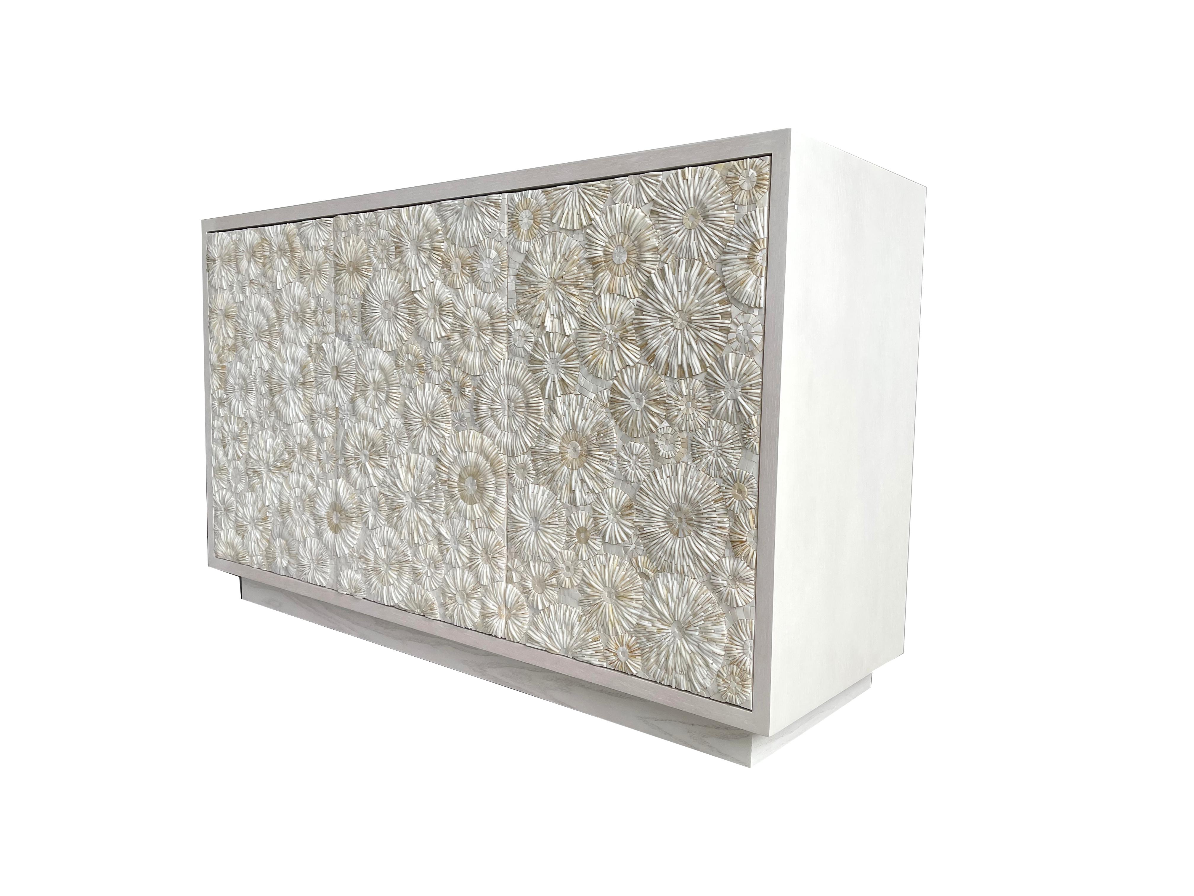 The Blossom Buffet is a two compartment cabinet with three touch latch doors and two compartments, one large and one small. The oak wood is finished in a washed ivory and the doors are each fully covered in our one of a kind blossom mosaic pattern