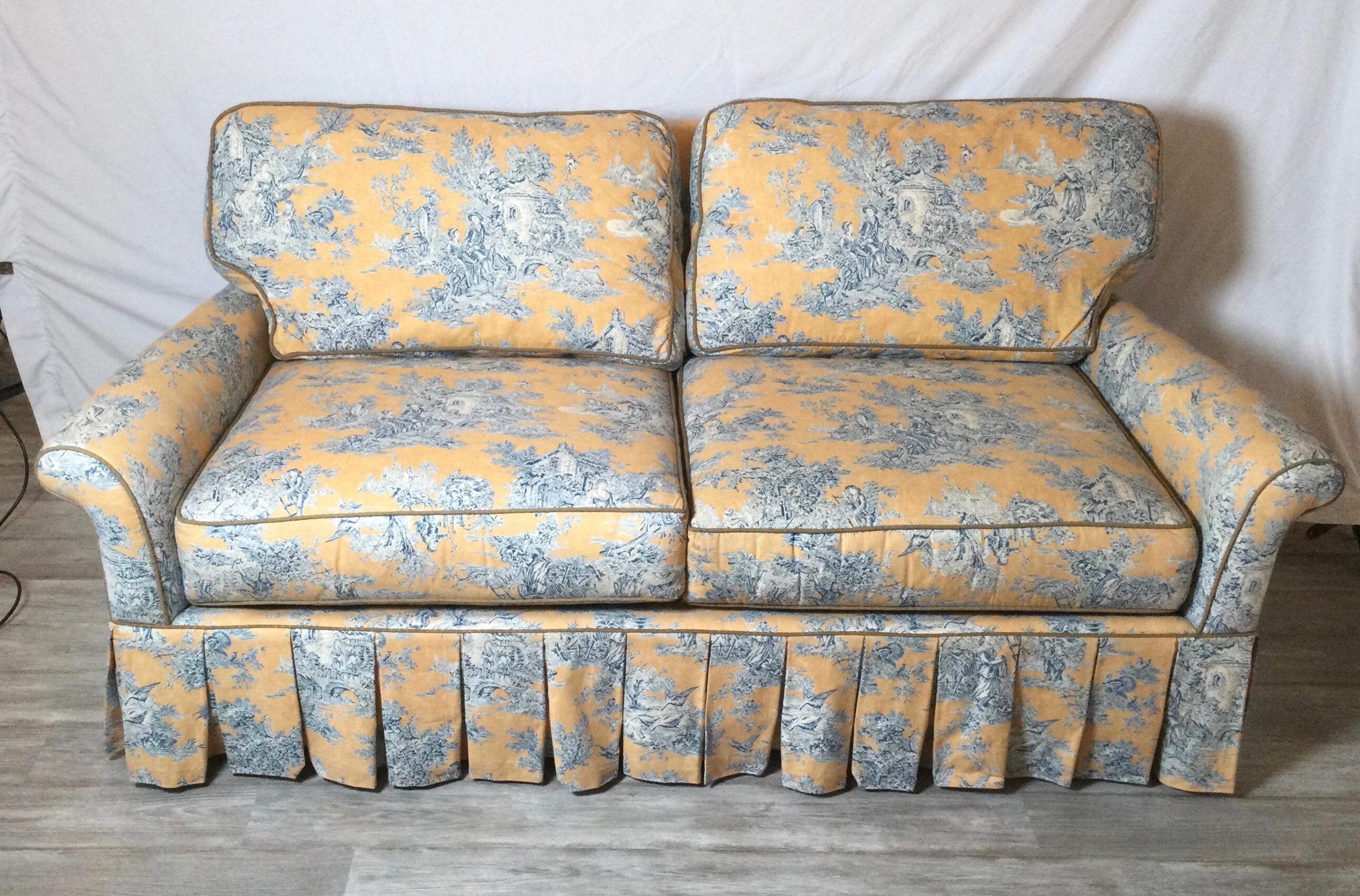 A classic traditional toile upholstered smaller sofa with kiln dried hardwood frame, hand tied hourglass coils and high quality fiber wrapped seat cushions. The smaller rolled arms with a high box pleated skirt. Measures: 76 inches long with a very