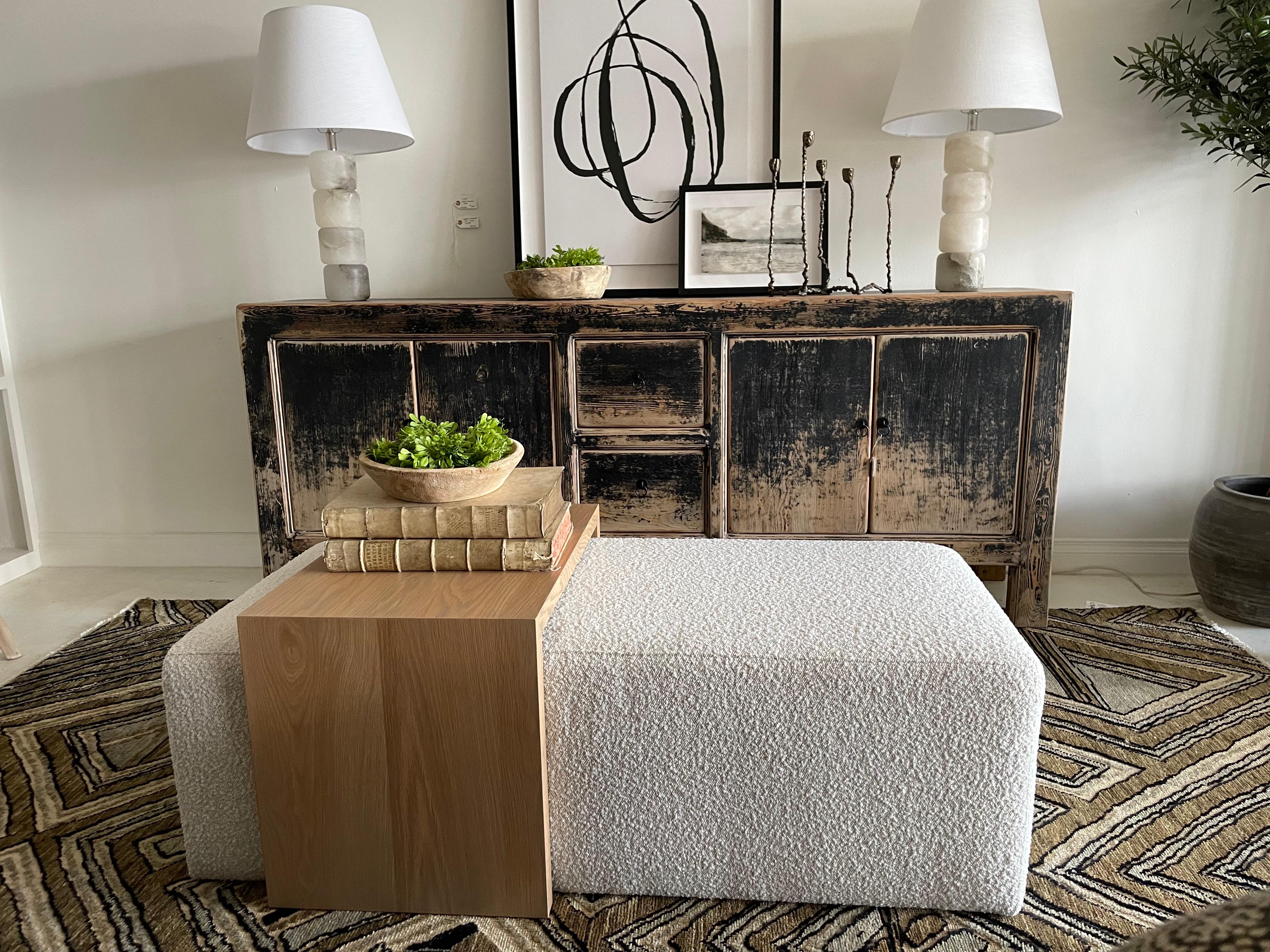 Custom Ottoman Cocktail Table in Creamy white boucle fabric.  Firmer foam holds its structure when using as a bench for seating.
White Oak waterfall style table can be used and moved for versatilily.
Ottoman: 54