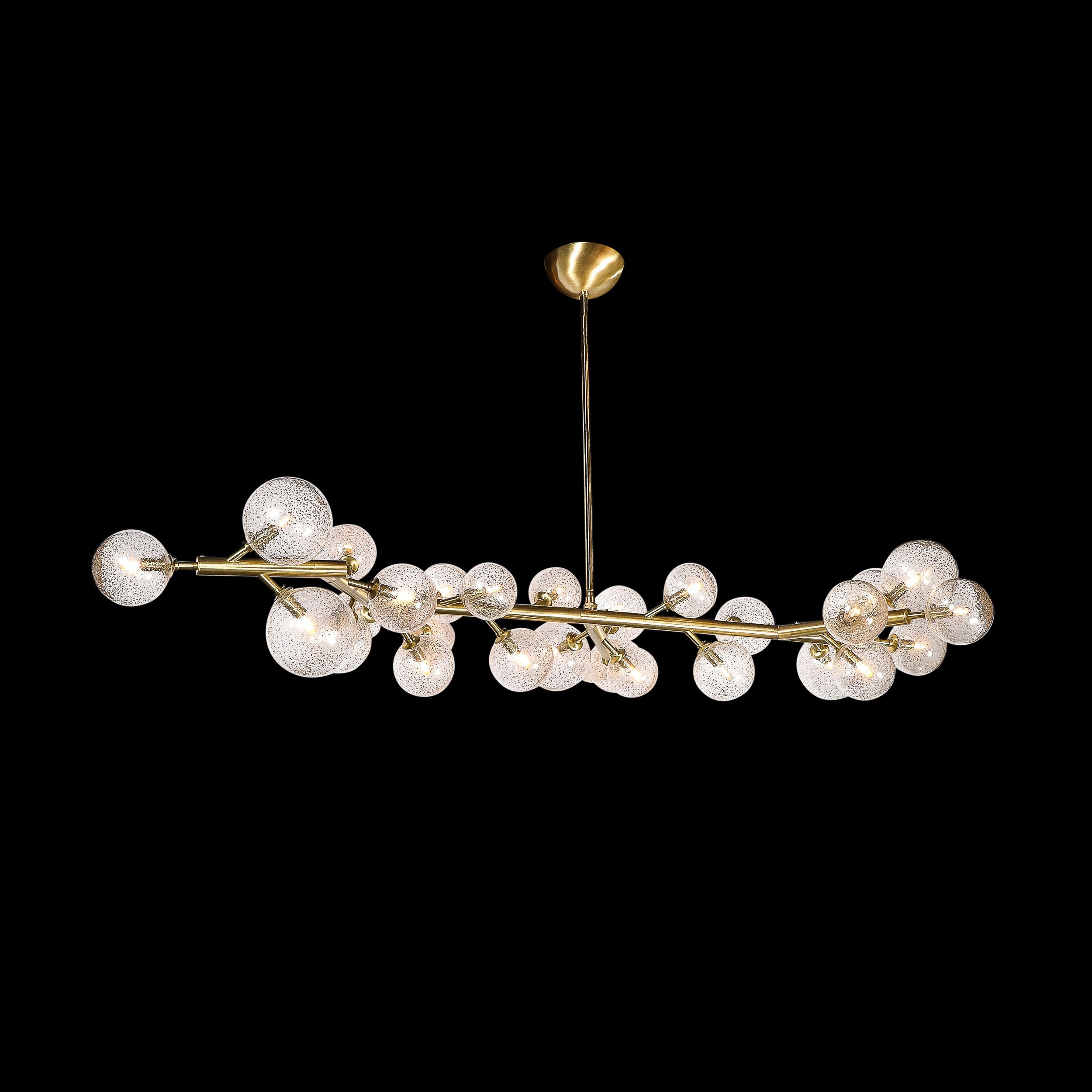 This stunningly elegant Custom Branch Form Hand-blown Murano Glass Chandelier in Transparent & 24Karat Gold Flecks & Brushed Brass Fittings originates from Italy during the 21st Century. Features an elongated branch form composition in a brushed